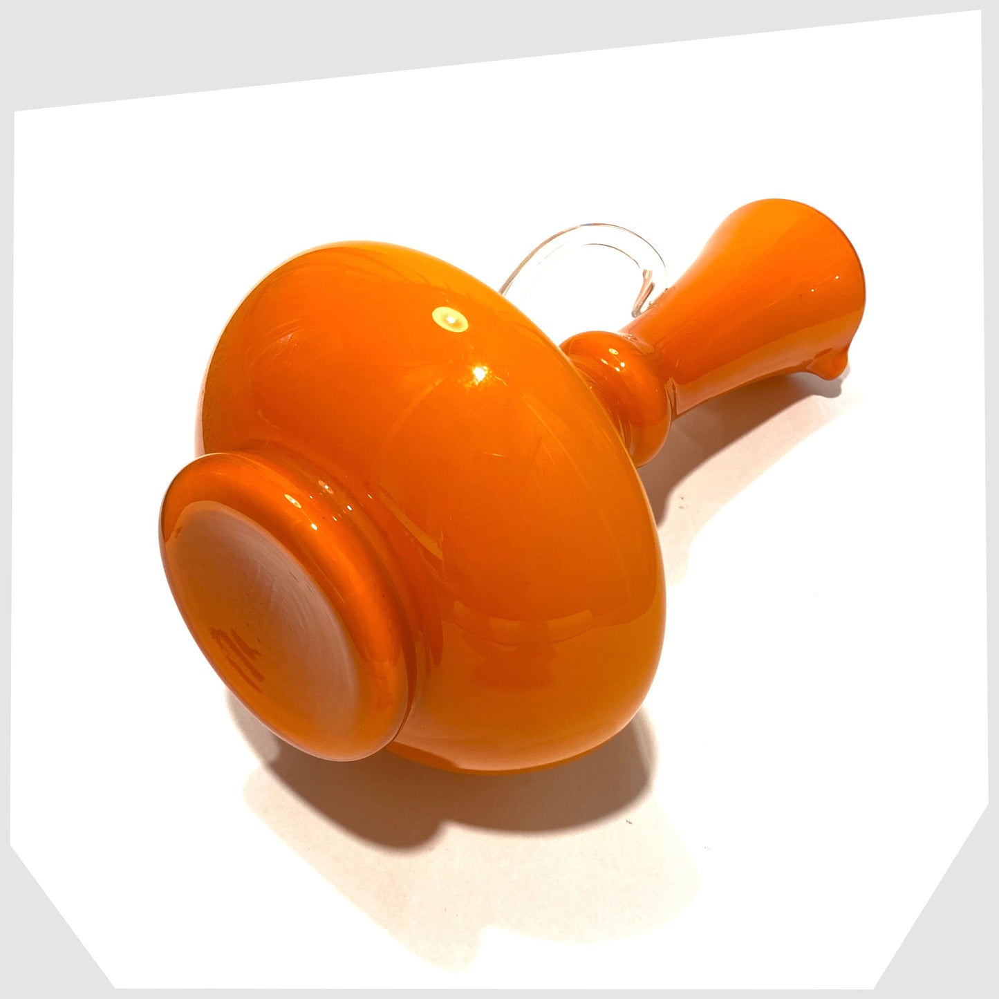 base of the empoli glass jug in vibrant orange cased glass with clear glass handle