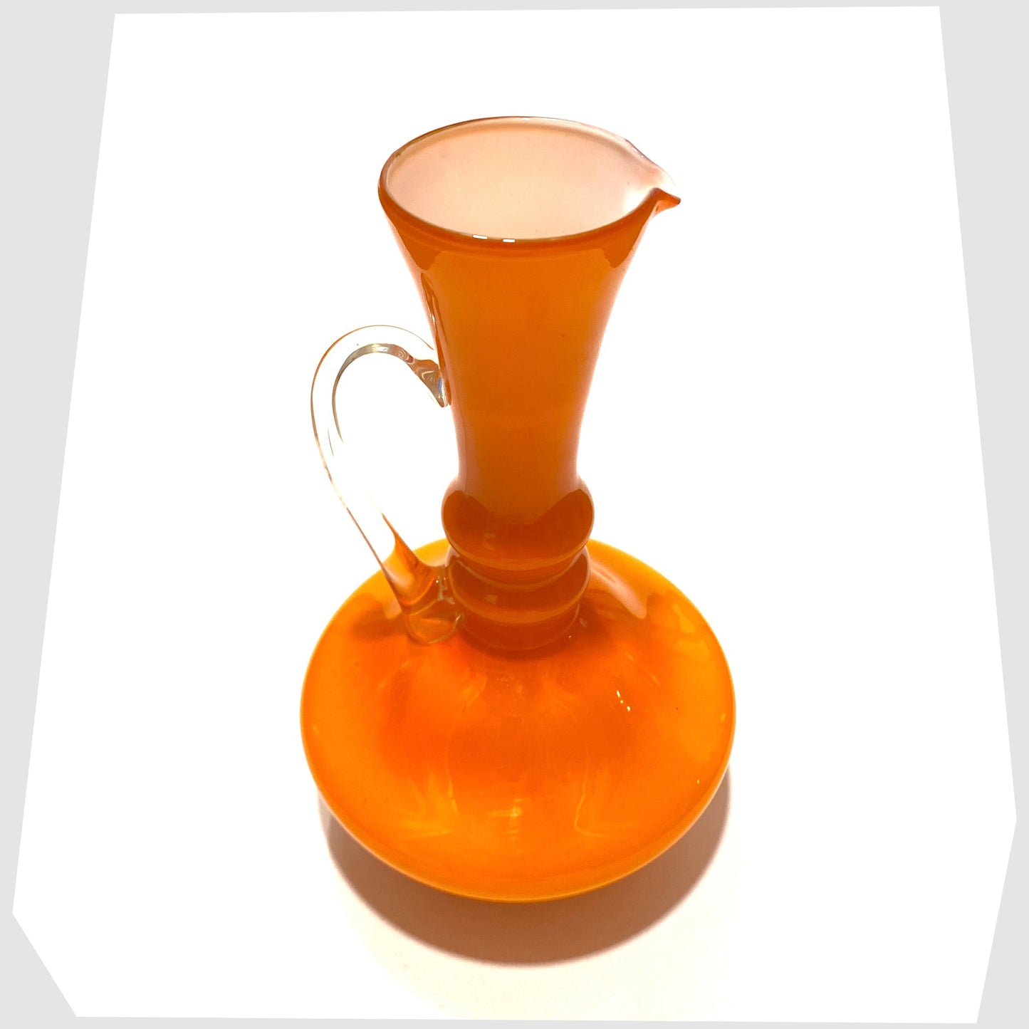 top lip and white inner of the empoli glass jug in vibrant orange cased glass with clear glass handle