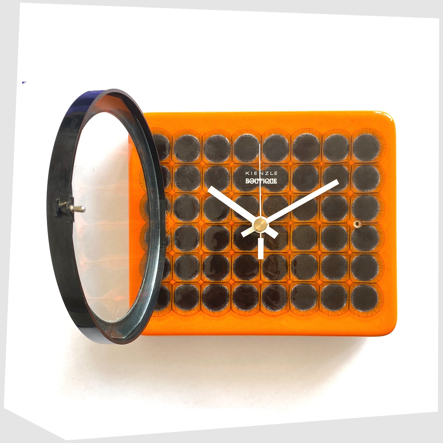 kienzle boutique wall clock made of vibrant orange ceramic with a geometric pattern of repeating circles