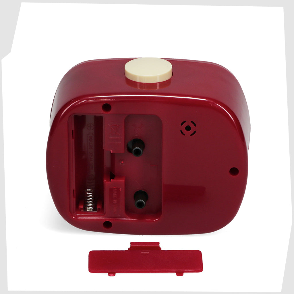 rear of the red retro alarm clock showing the adjusting dials and battery compartment