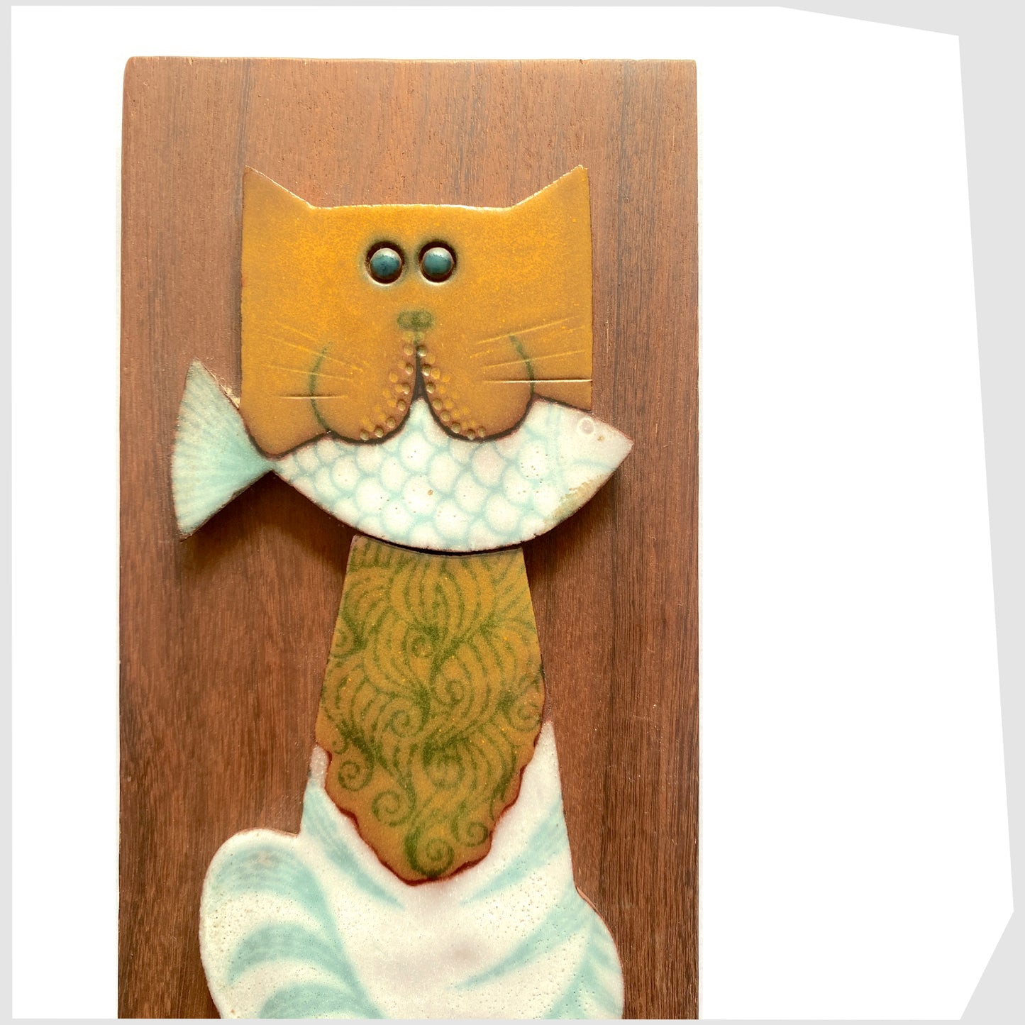 cat with fish in its mouth Horrnsea Pottery Muramic Wall Plaque, detail of the cats face holding the while fish