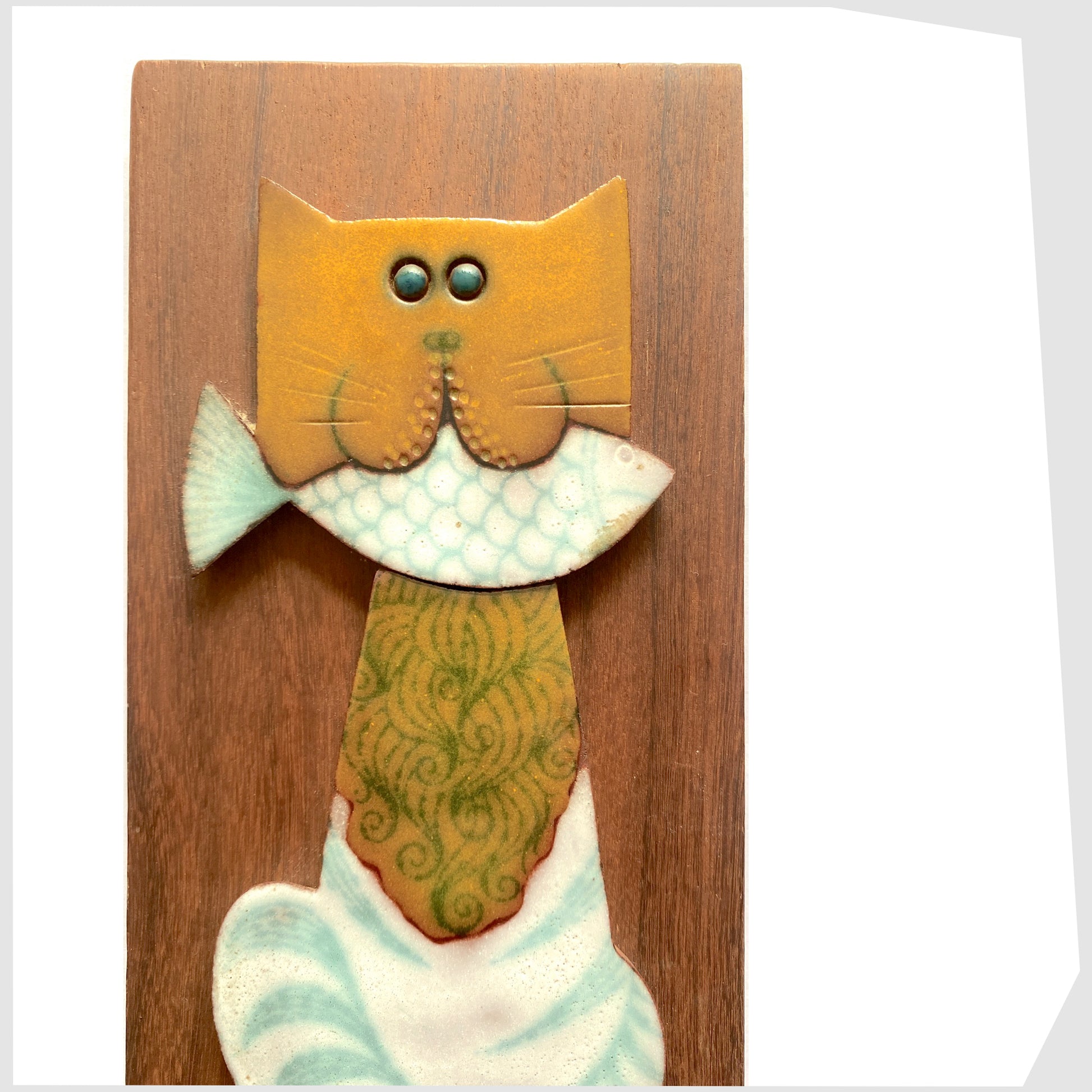 cat with fish in its mouth Horrnsea Pottery Muramic Wall Plaque, detail of the cats face holding the while fish