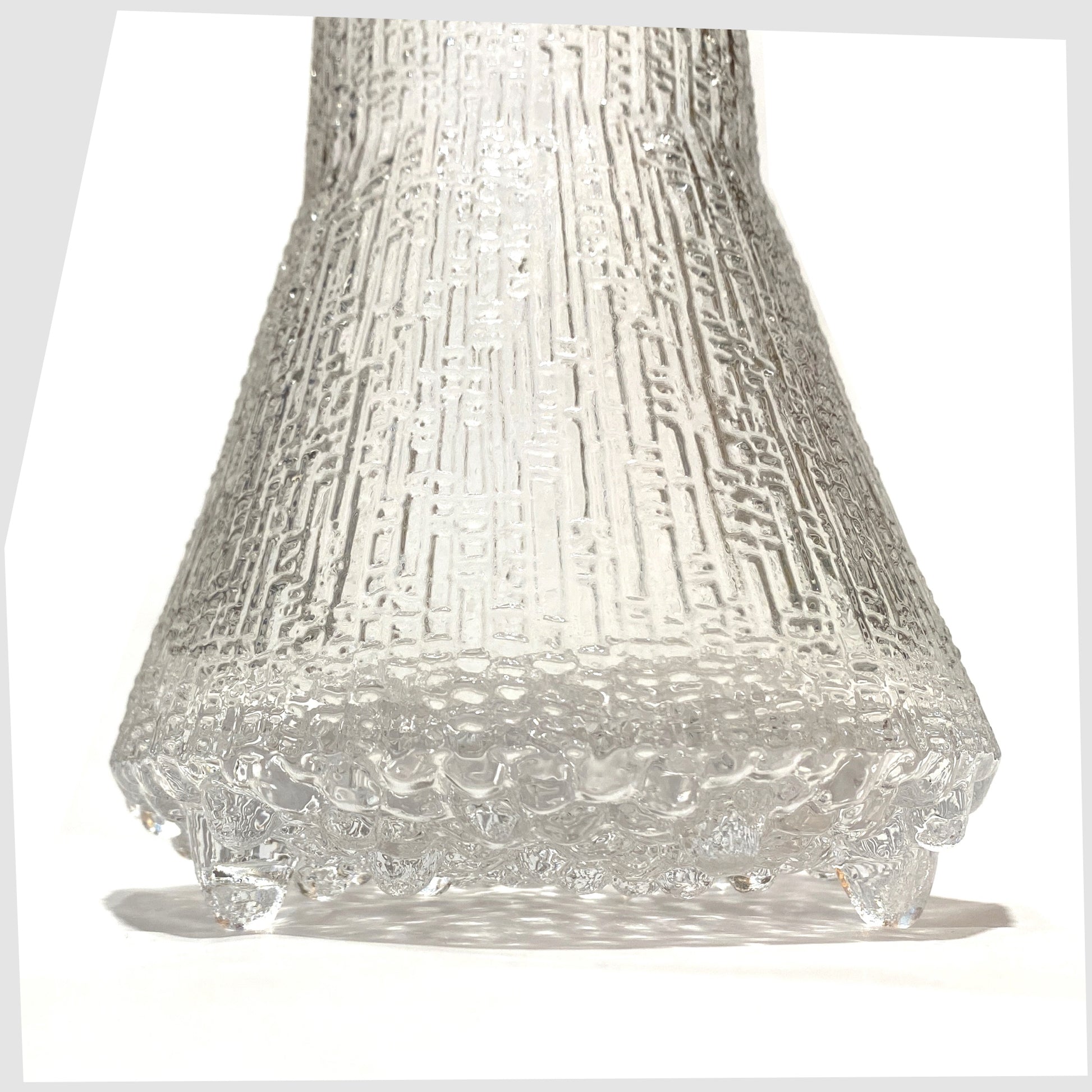 Base section of the Iittala Ultima Thule Glass Pitcher in clear glass with an ice textured finish, shown on a white background