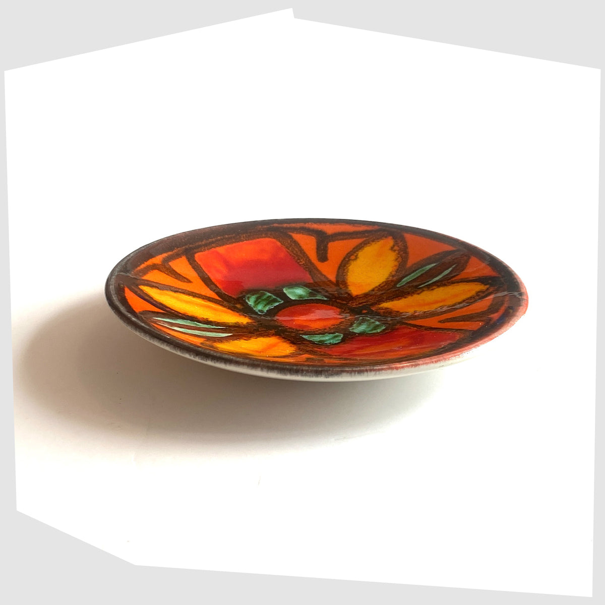 1970s Poole Pottery Delphis Pin Dish, shape 49, by Janet Laird glazed in a vivid orange with fluid forms of green and yellow glaze- Shown on a white background