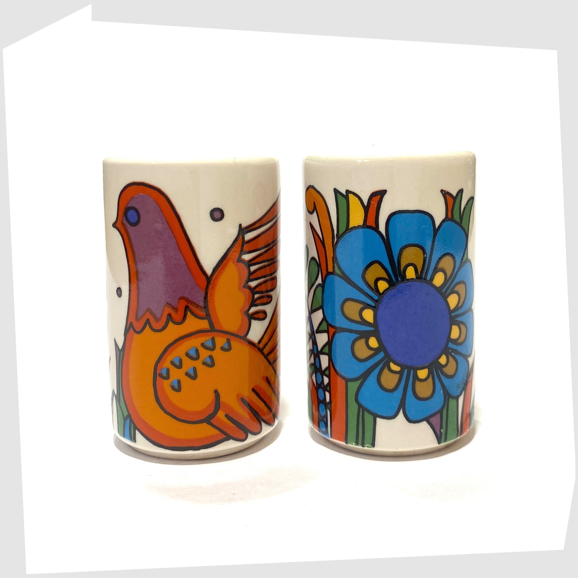 Vintage 1967 Villeroy and Boch Acapulco Salt & Pepper Shakers showing the full wrap around design of blue flowers and orange bird, shown on a white background