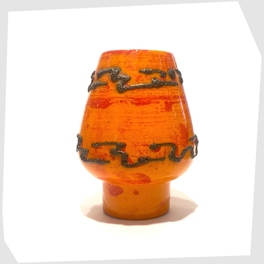 Orange ceramic vase with decorative patterns of black fat lava on a white background