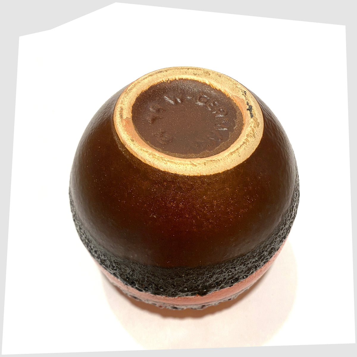 Base of the Bay Keramik 64-12 vase with volcanic red and orange glaze with bands of black fat lava, shown on a white background
