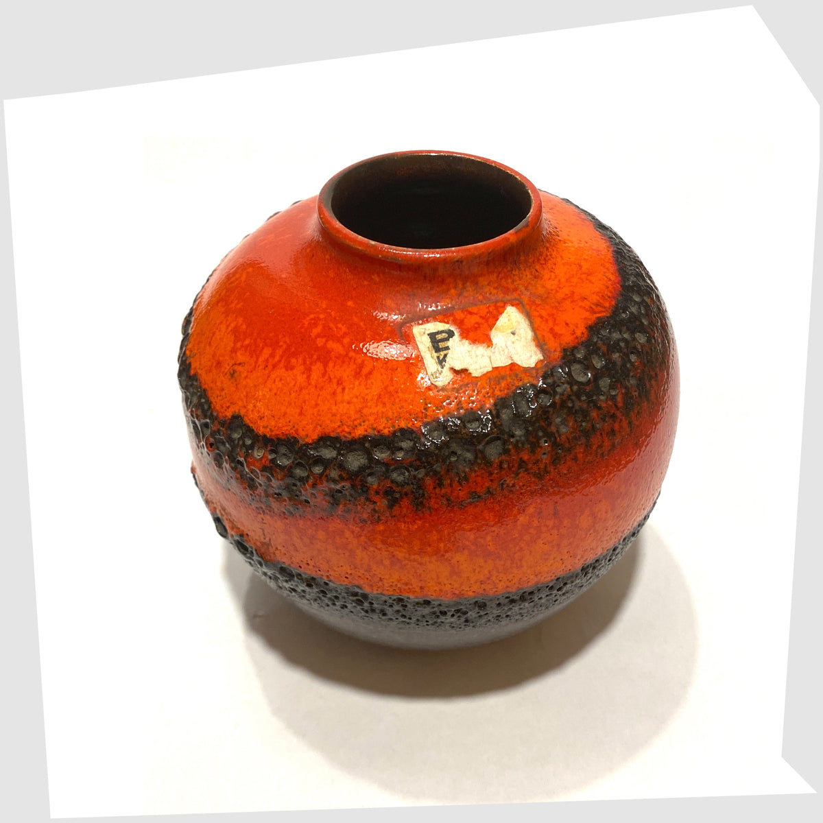 Top rim of the Bay Keramik 64-12 vase with volcanic red and orange glaze with bands of black fat lava, shown on a white background