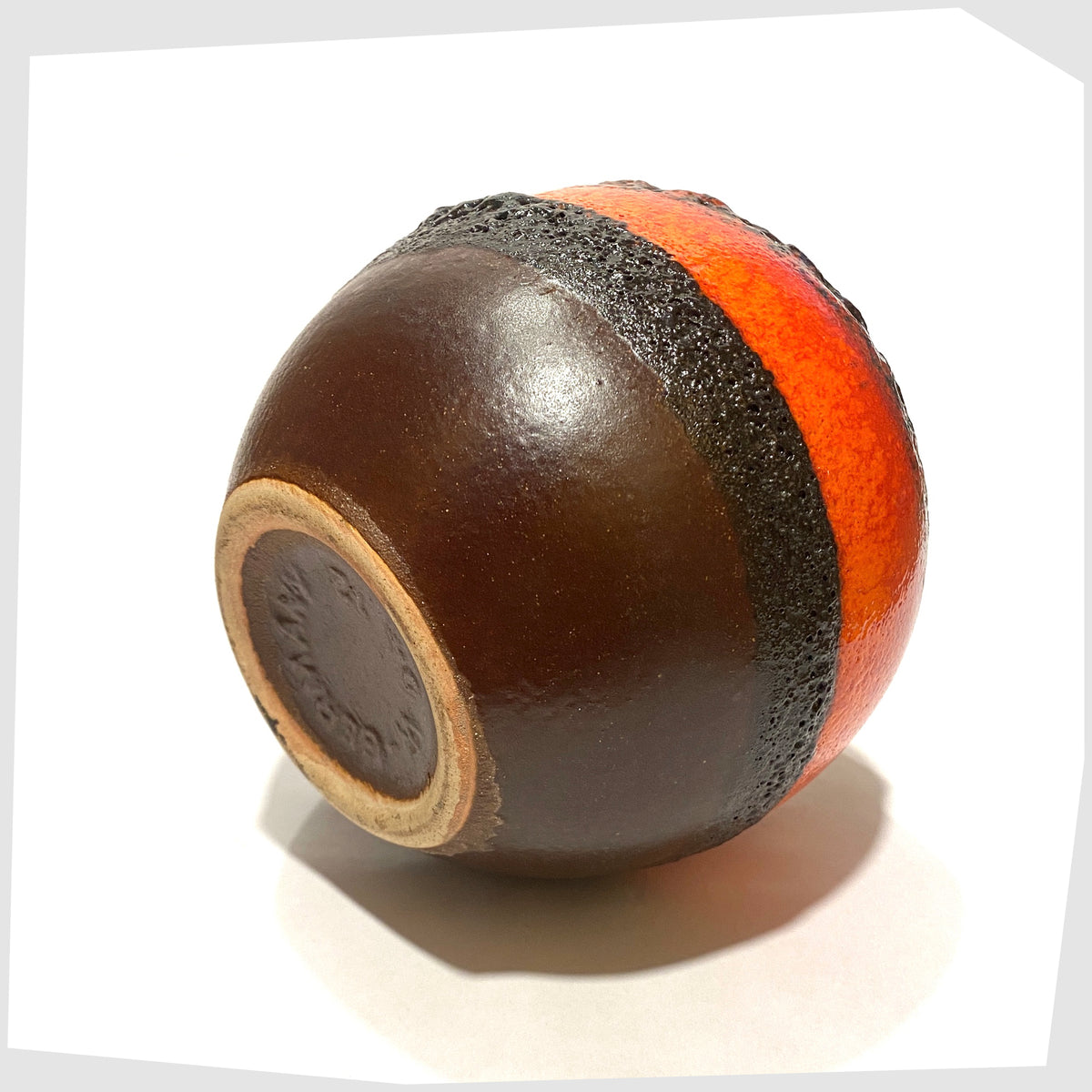 Underneath of the Bay Keramik 64-12 vase with volcanic red and orange glaze with bands of black fat lava, shown on a white background