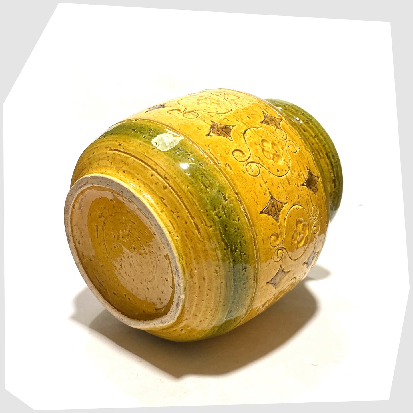 Base of the Bitossi Arabesque Lidded Jar in yellow glaze with green bands and impressed markings, shown on a white background