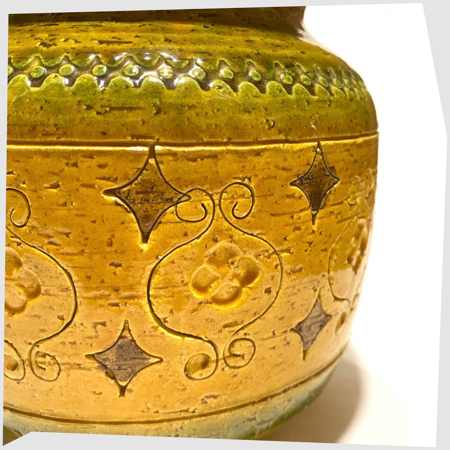 Close up of the Bitossi Arabesque Lidded Jar in yellow glaze with green bands and impressed markings, shown on a white background