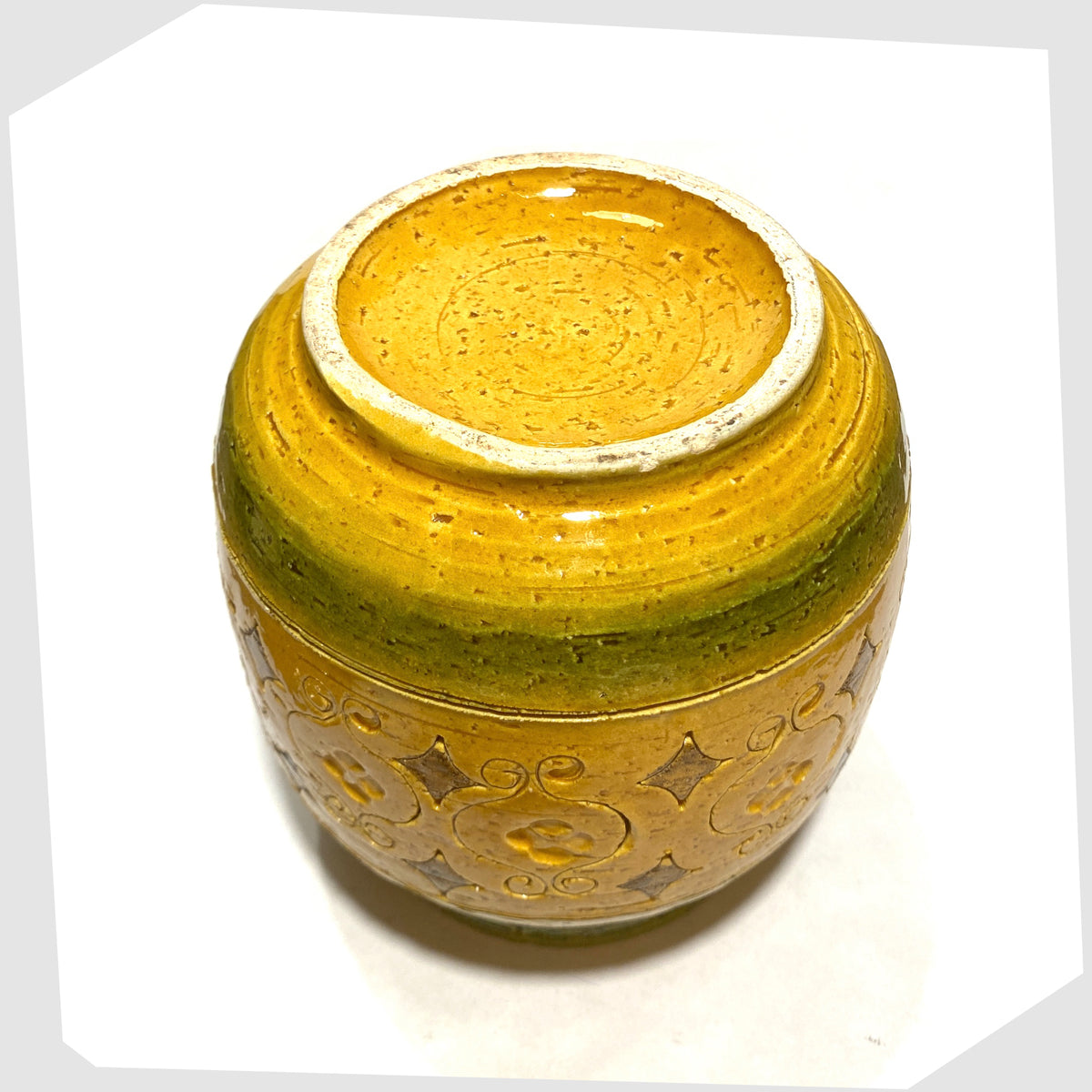 Underneath of the Bitossi Arabesque Lidded Jar in yellow glaze with green bands and impressed markings, shown on a white background