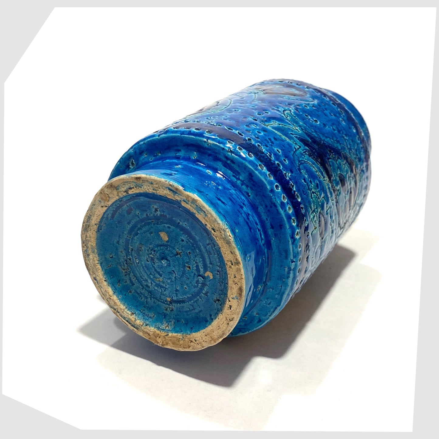 Base of the Bitossi Liberty Vase in rimini blu glaze, designed by Aldo Londi, featuring a central band of impressed aisley patterns, shown on a white background