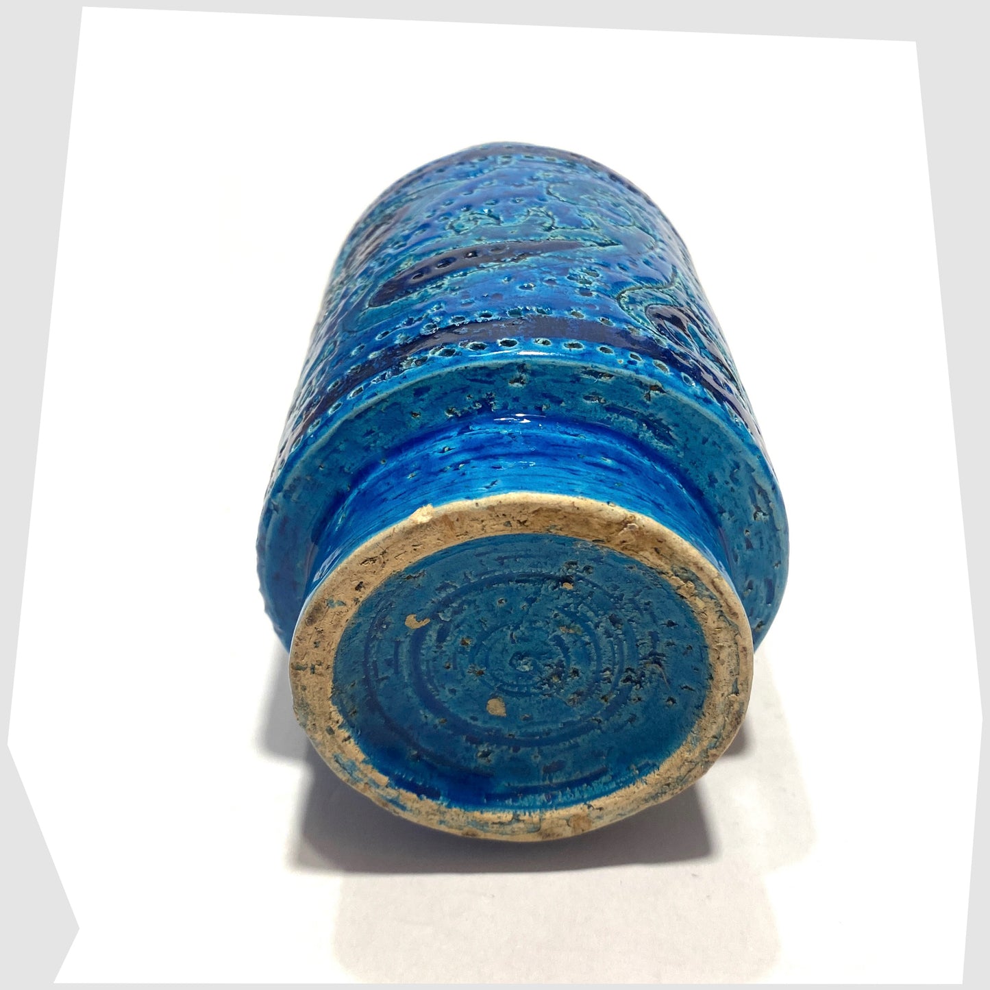 Base of the Bitossi Liberty Vase in rimini blu glaze, designed by Aldo Londi, featuring a central band of impressed aisley patterns, shown on a white background
