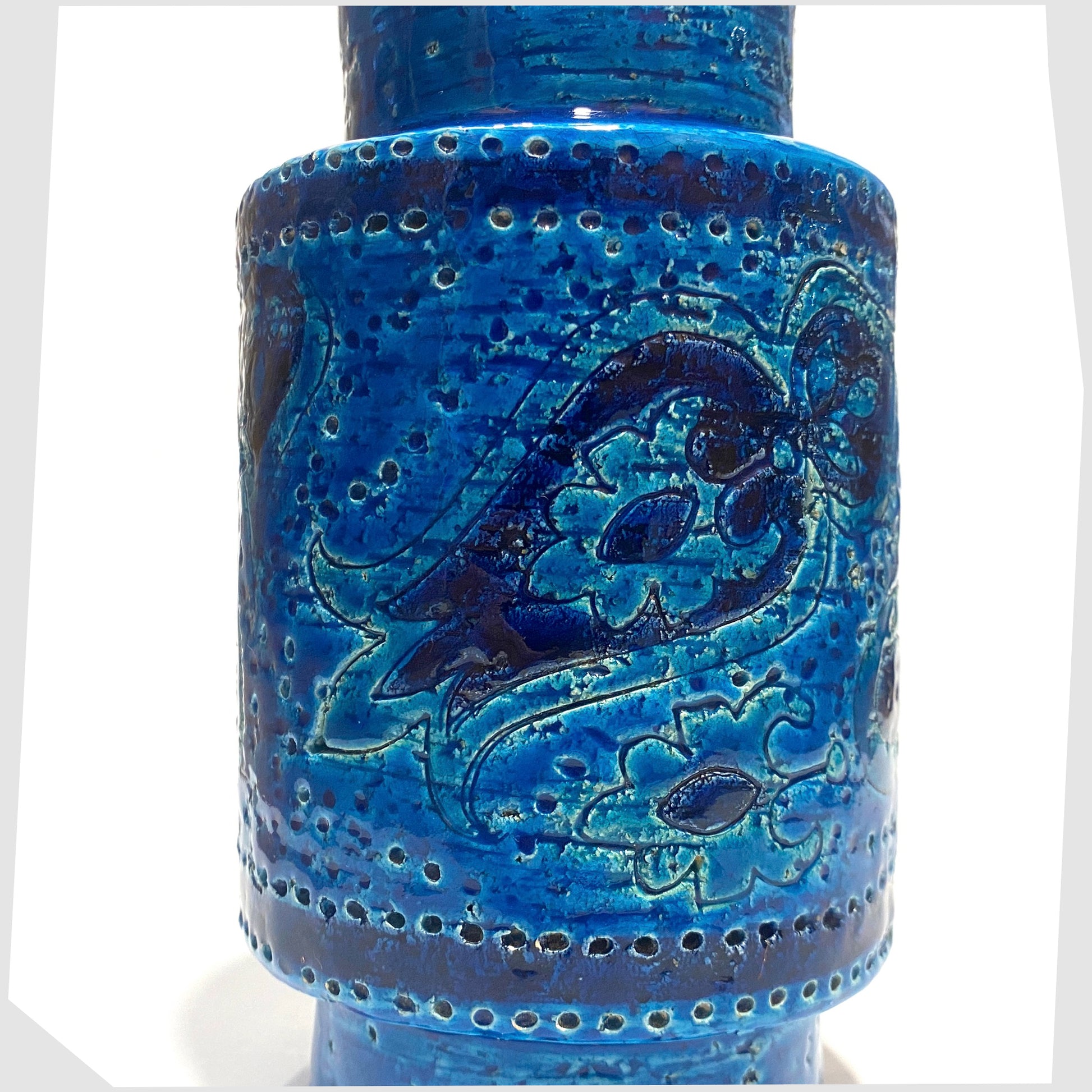 Close up of the Bitossi Liberty Vase in rimini blu glaze, designed by Aldo Londi, featuring a central band of impressed aisley patterns, shown on a white background