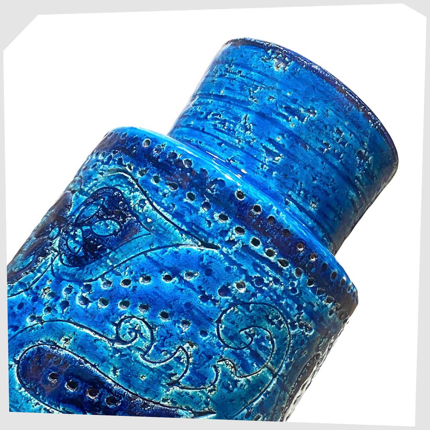 Close up of the upper section of the Bitossi Liberty Vase in rimini blu glaze, designed by Aldo Londi, featuring a central band of impressed aisley patterns, shown on a white background