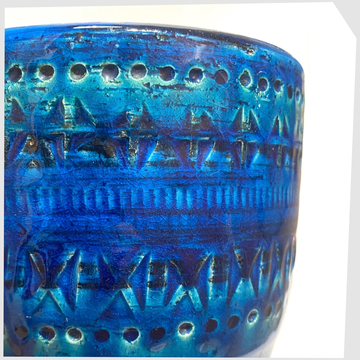 Close up of the Bitossi Rimini Blue Planter designed by Aldo Londi in a rich blue glaze with an array of impressed markings, shown on a white background