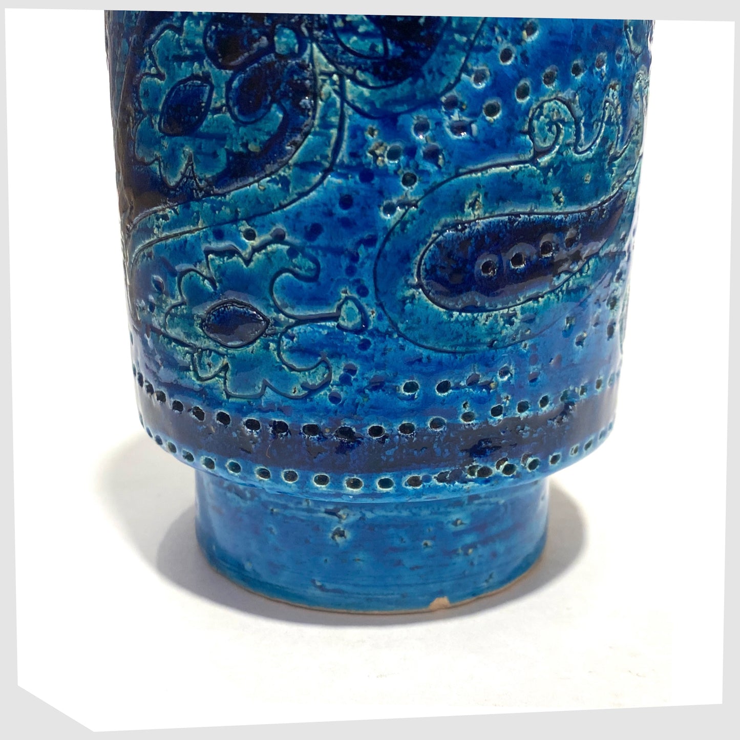 Lower section of the Bitossi Liberty Vase in rimini blu glaze, designed by Aldo Londi, featuring a central band of impressed aisley patterns, shown on a white background