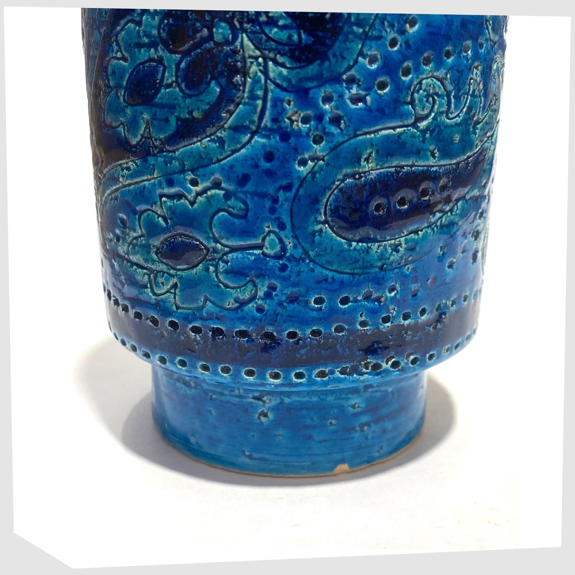 Lower section of the Bitossi Liberty Vase in rimini blu glaze, designed by Aldo Londi, featuring a central band of impressed aisley patterns, shown on a white background