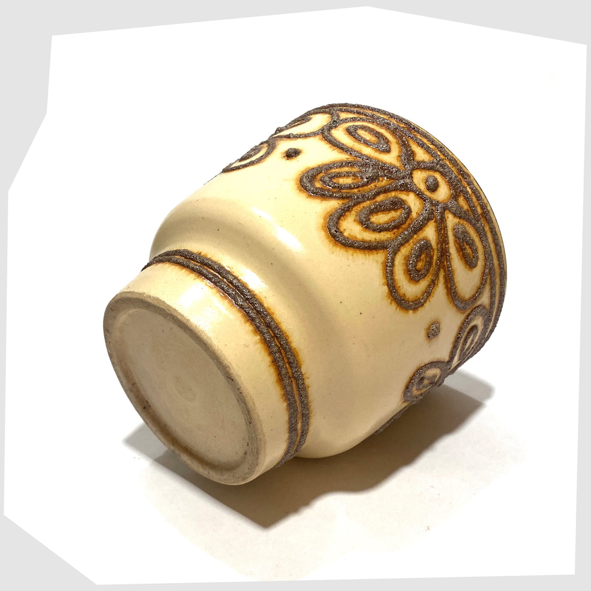 Base of the B.P.F. Heffen Planter in a matte beige glaze with brown fat lava design, shown on a white background