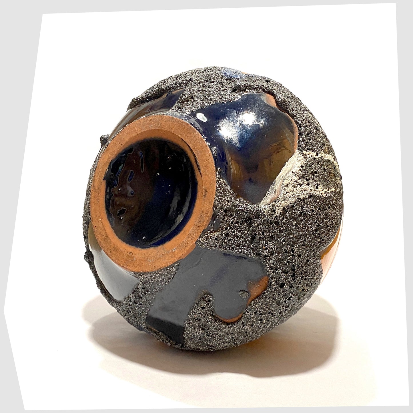 Base of the Carsten Tonnieshof Vase in asteroid form with bands of cool grey, volcanic orange and blue fat lava