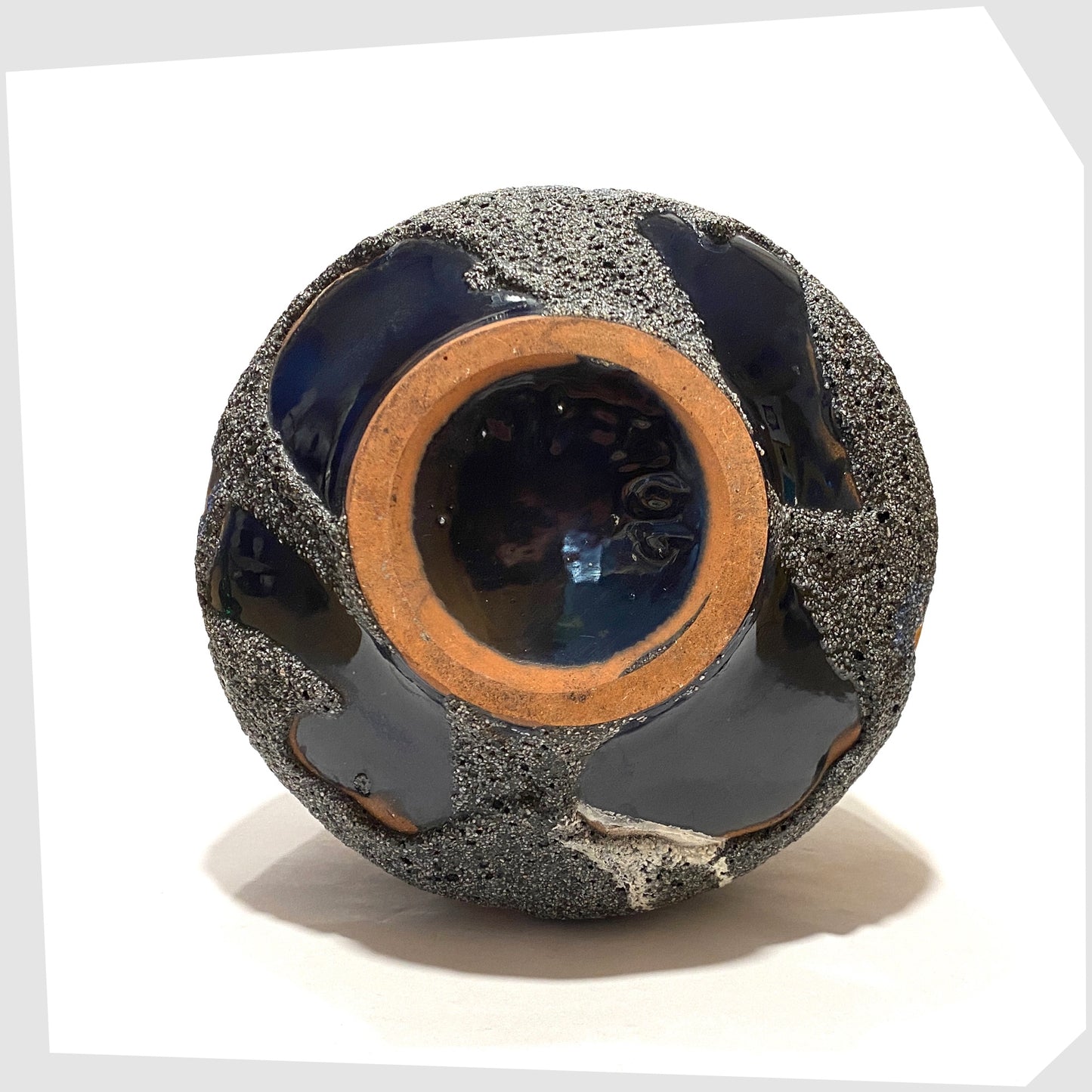 Underneath of the Carsten Tonnieshof Vase in asteroid form with bands of cool grey, volcanic orange and blue fat lava