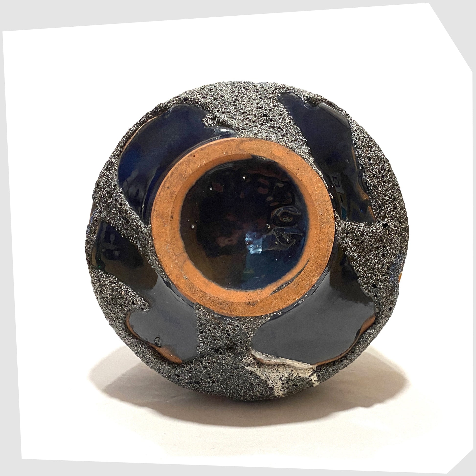 Underneath of the Carsten Tonnieshof Vase in asteroid form with bands of cool grey, volcanic orange and blue fat lava