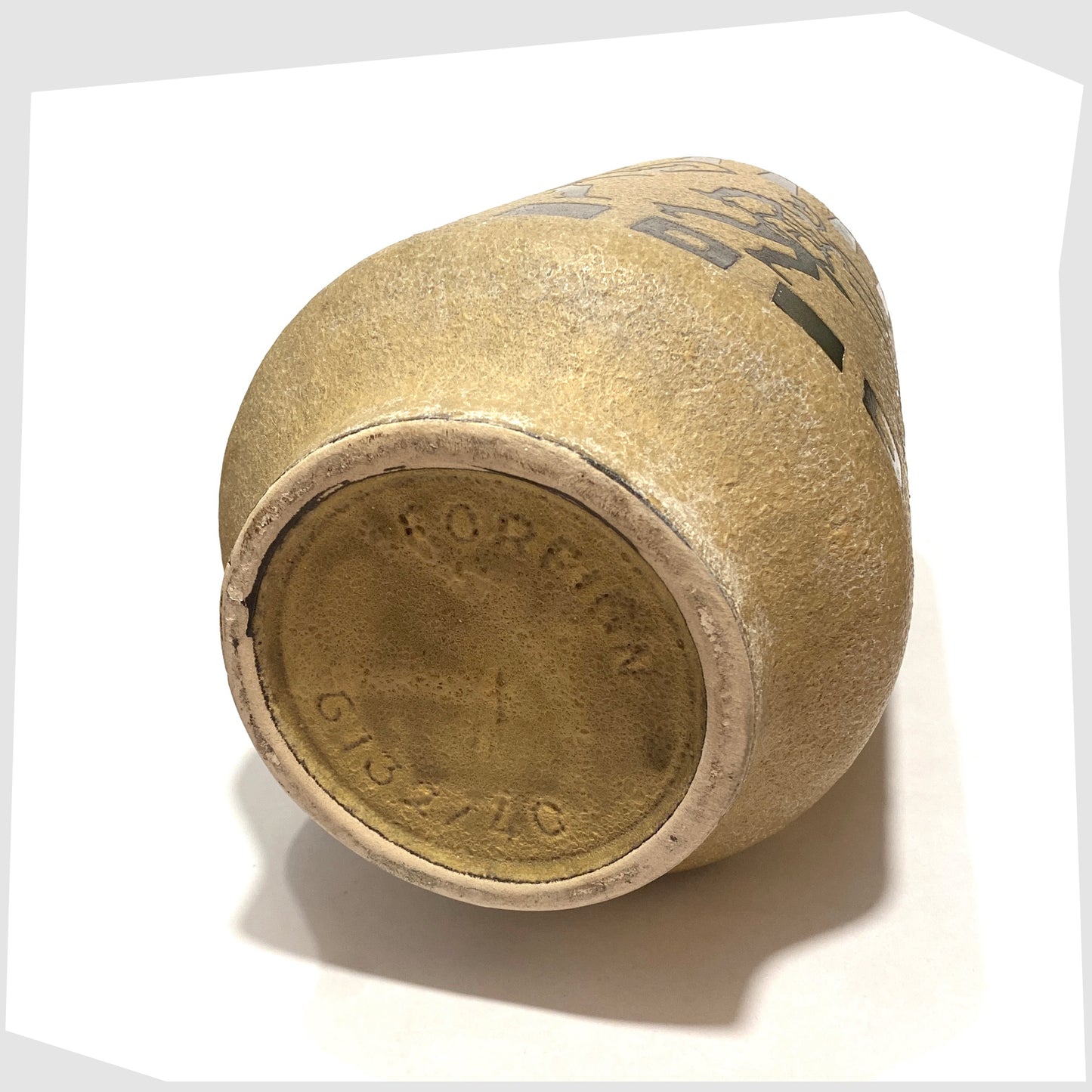 Base of the Ceramano 6132/40 Floor Vase designed by Hans Welling featuring a wrap around design of Roman soldiers on a textured beige glaze, shown on a white background