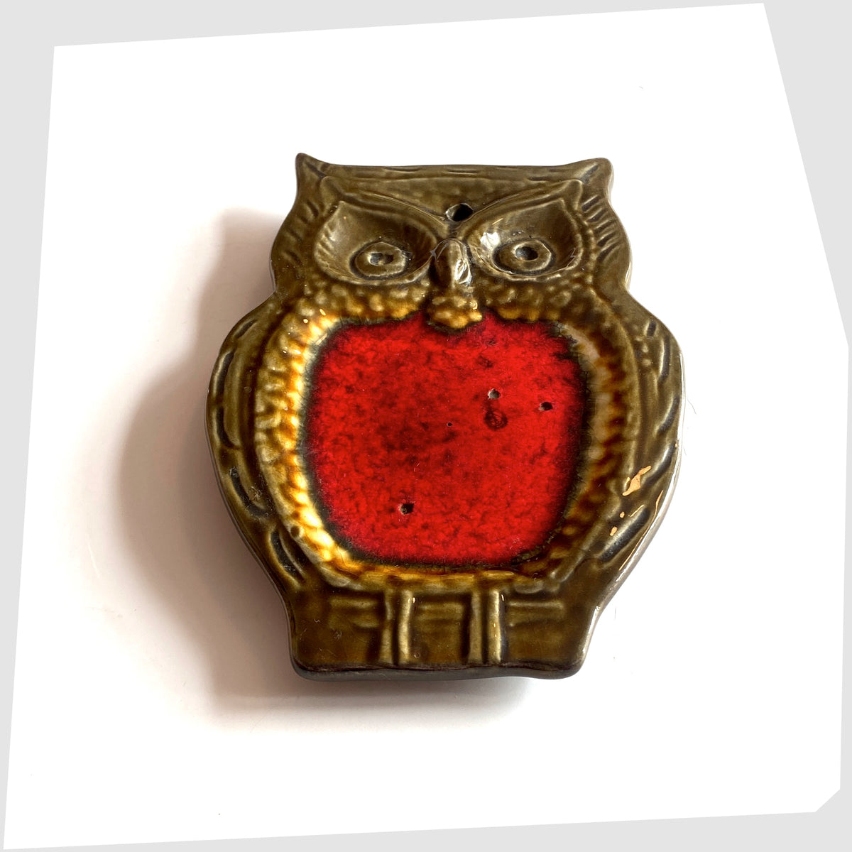 Angled view of the Mid-century ceramic owl shaped spoon rest with volcanic red glaze, shown on a white background