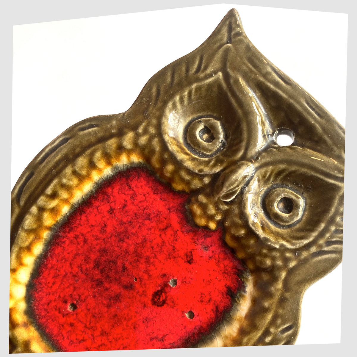 Close up of the Mid-century ceramic owl shaped spoon rest with volcanic red glaze, shown on a white background
