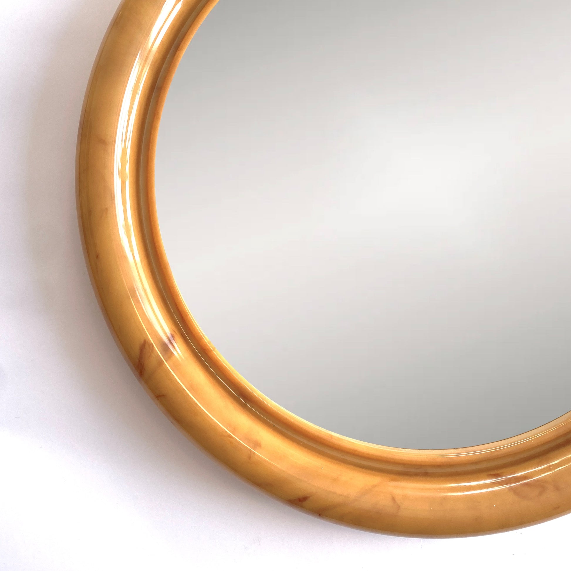 close up of the Crayonne Circular Wall Mirror in a marbled mustard colour way