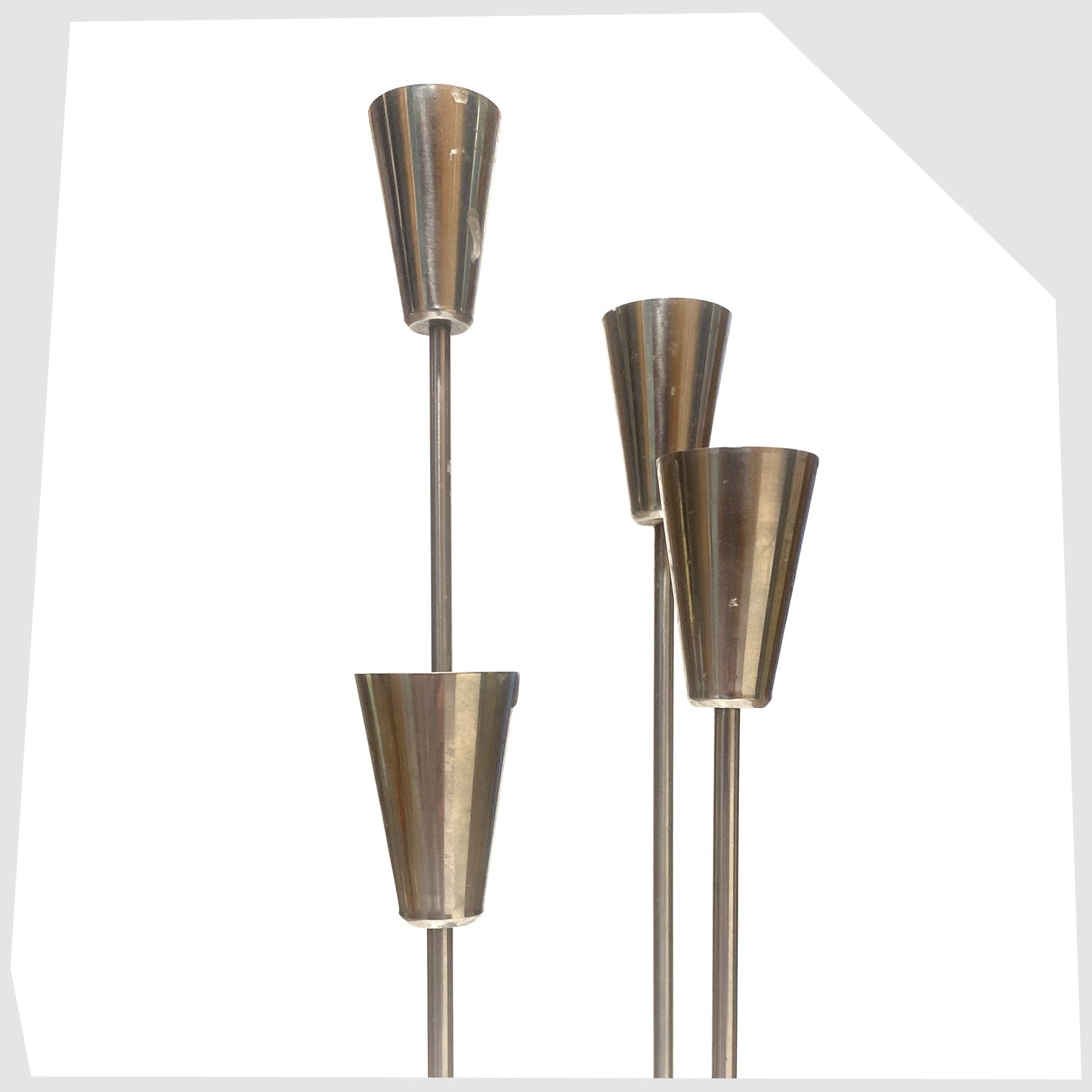 Four candle holders on the Danish Candlestick Holder by MG Design, made of polished stainless steel