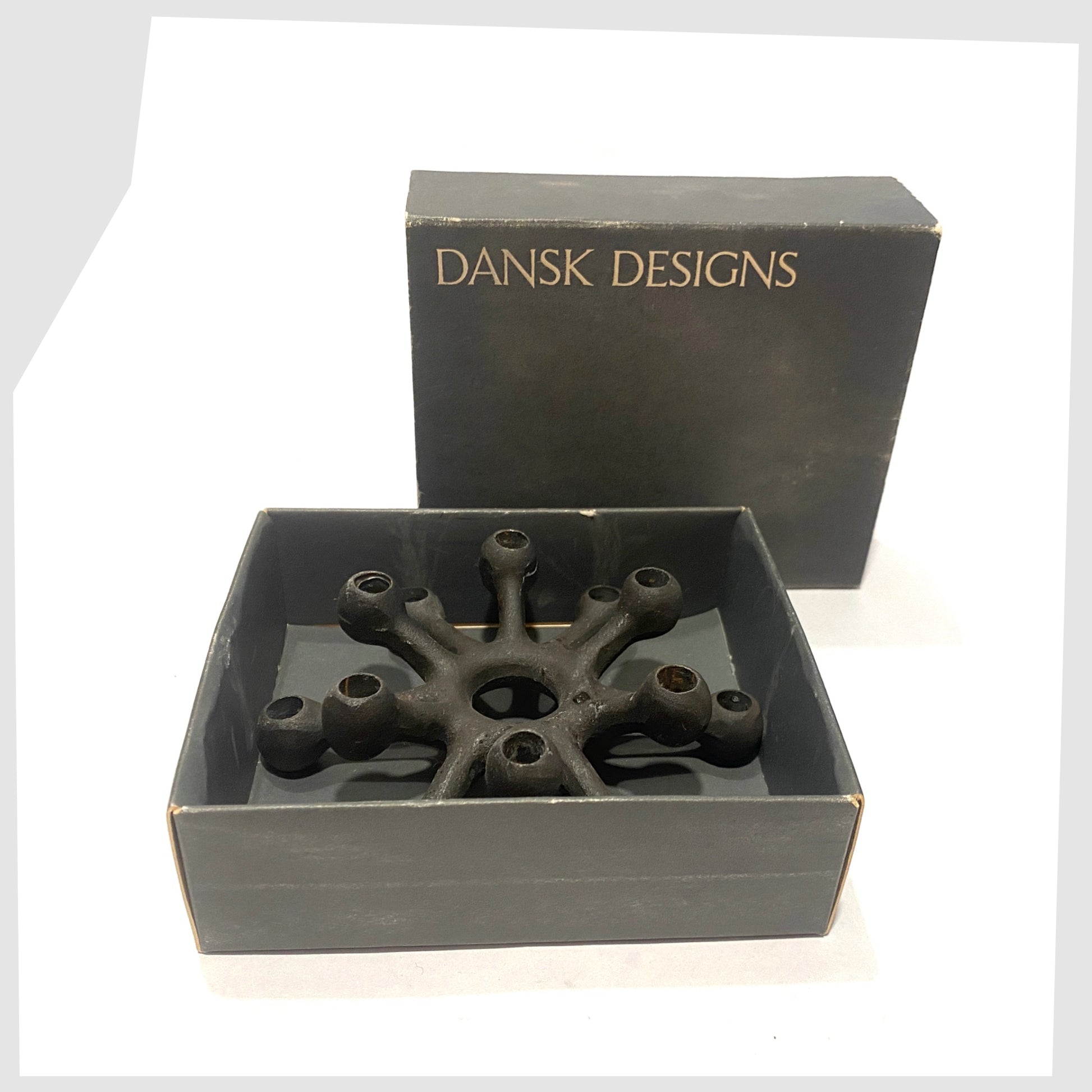 Danish Design Spider Candleholder in black cast iron, shown in its original box on a white background