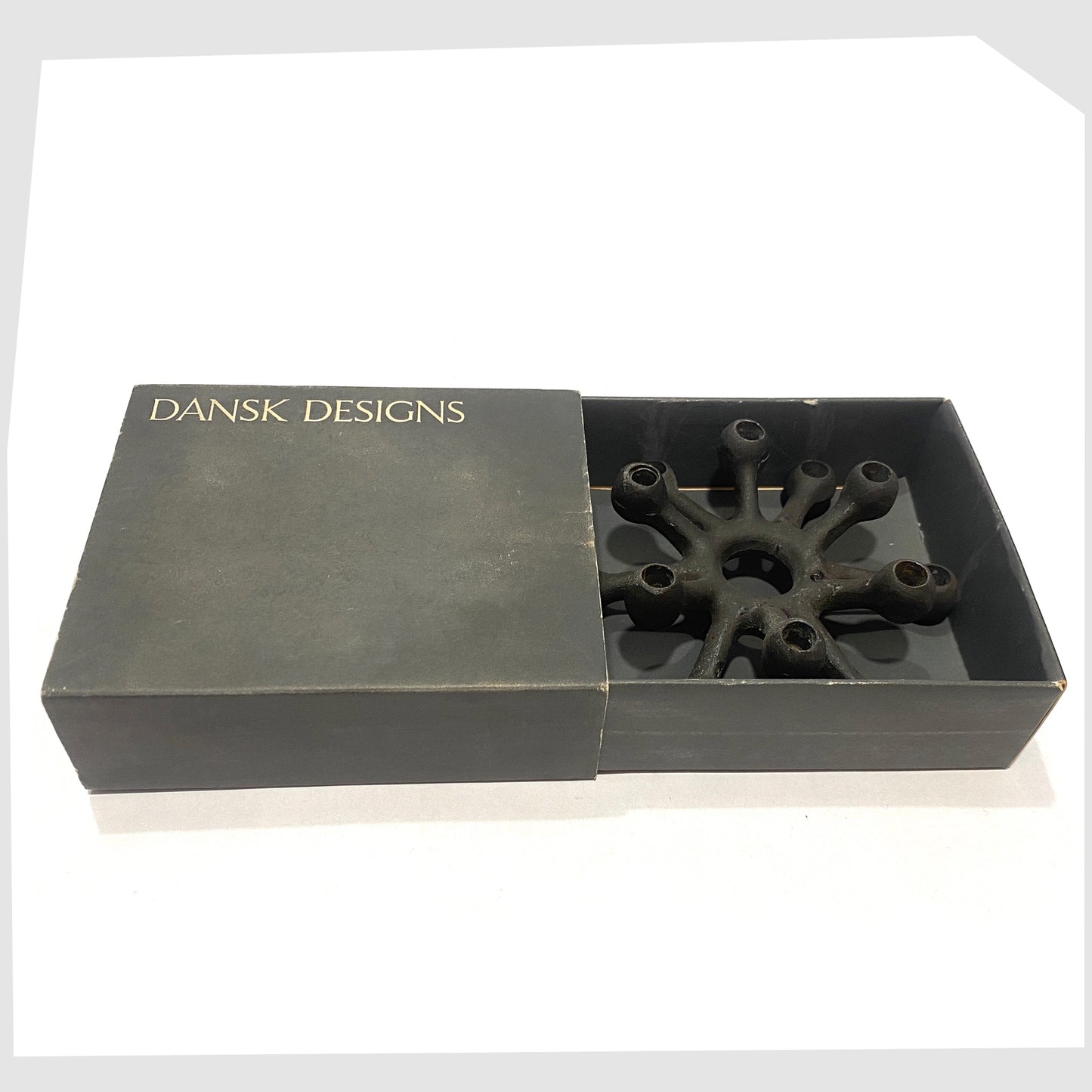 Danish Design Spider Candleholder in black cast iron, shown inside its original box on a white background
