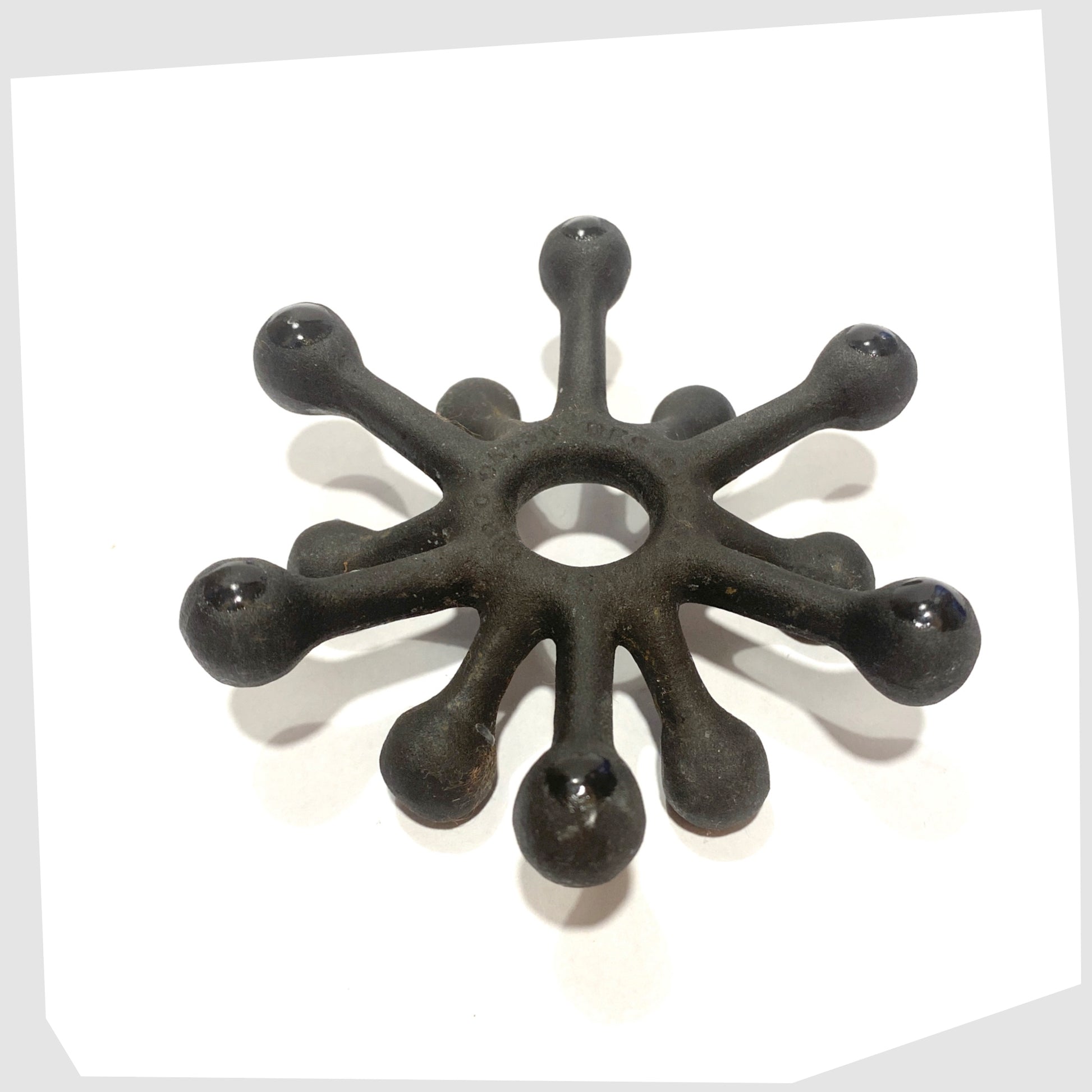 base of the Danish Design Spider Candleholder in black cast iron, shown on a white background