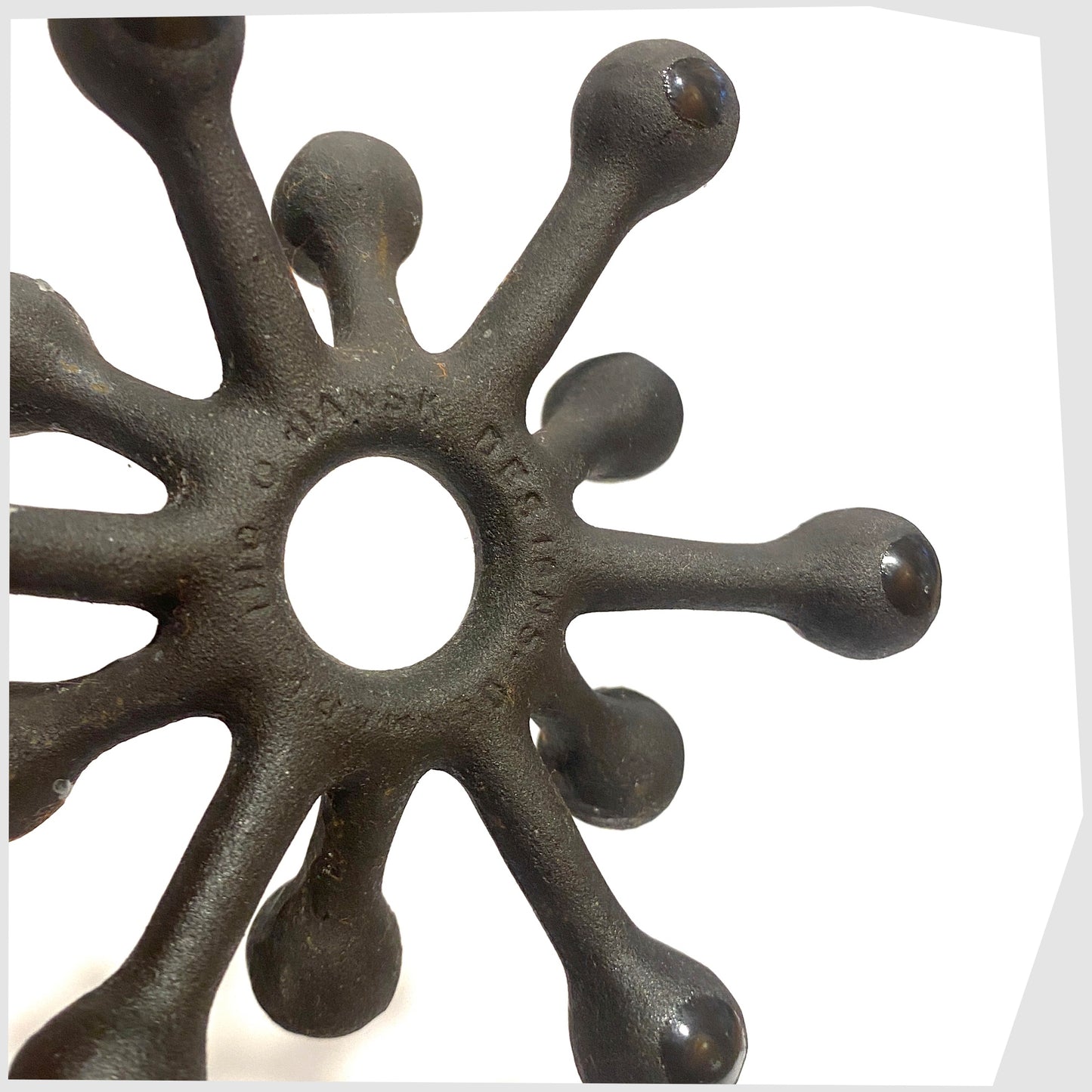 Close up of the Danish Design Spider Candleholder in black cast iron, shown on a white background