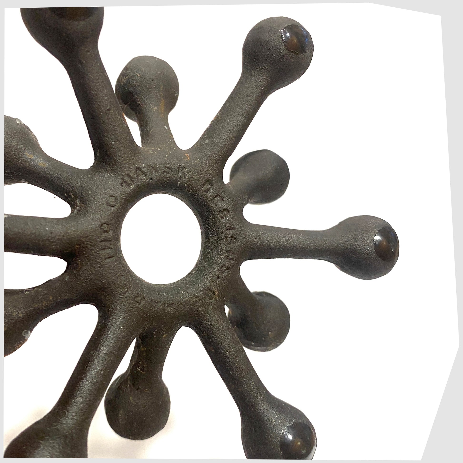 Close up of the Danish Design Spider Candleholder in black cast iron, shown on a white background