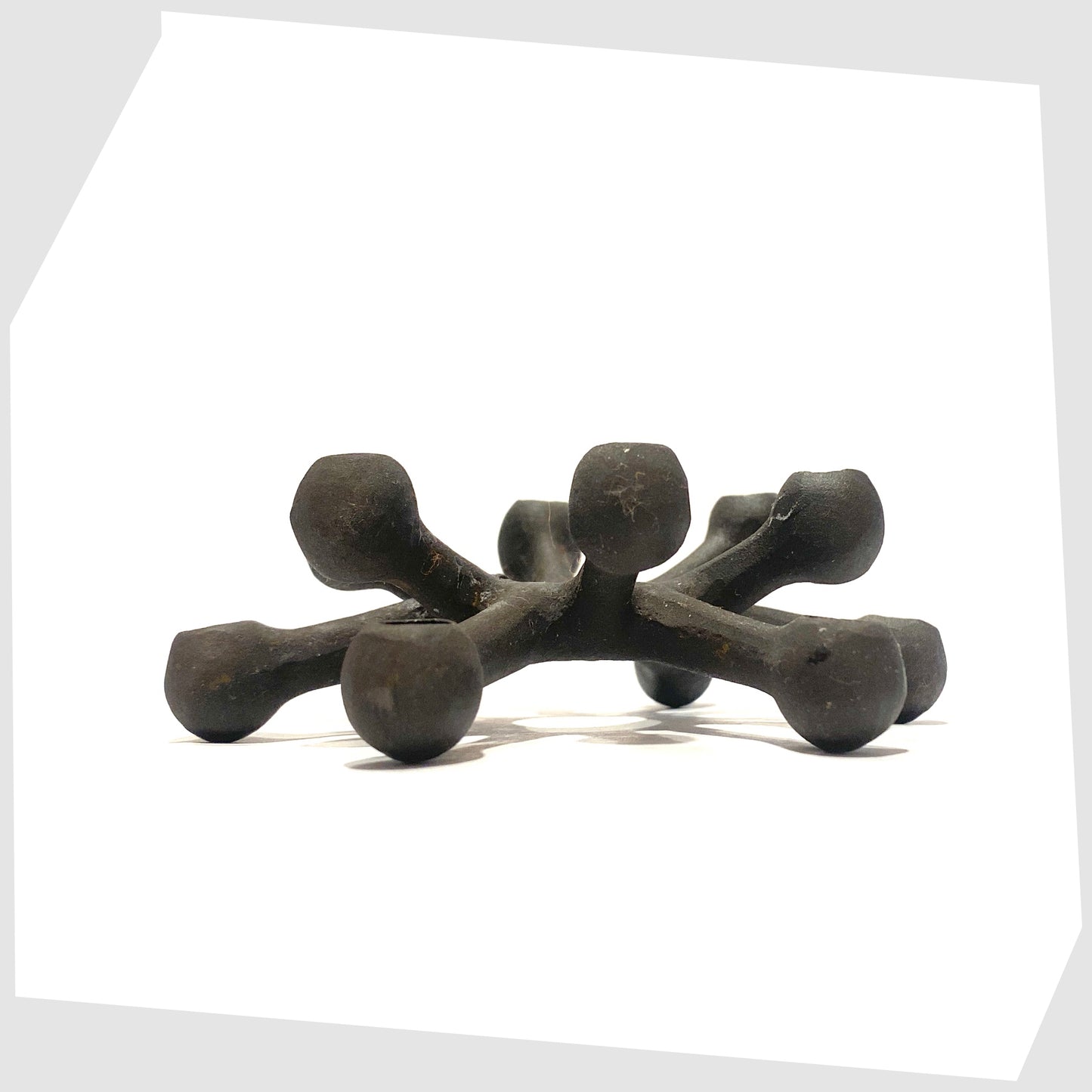 side profile of the Danish Design Spider Candleholder in black cast iron, shown on a white background