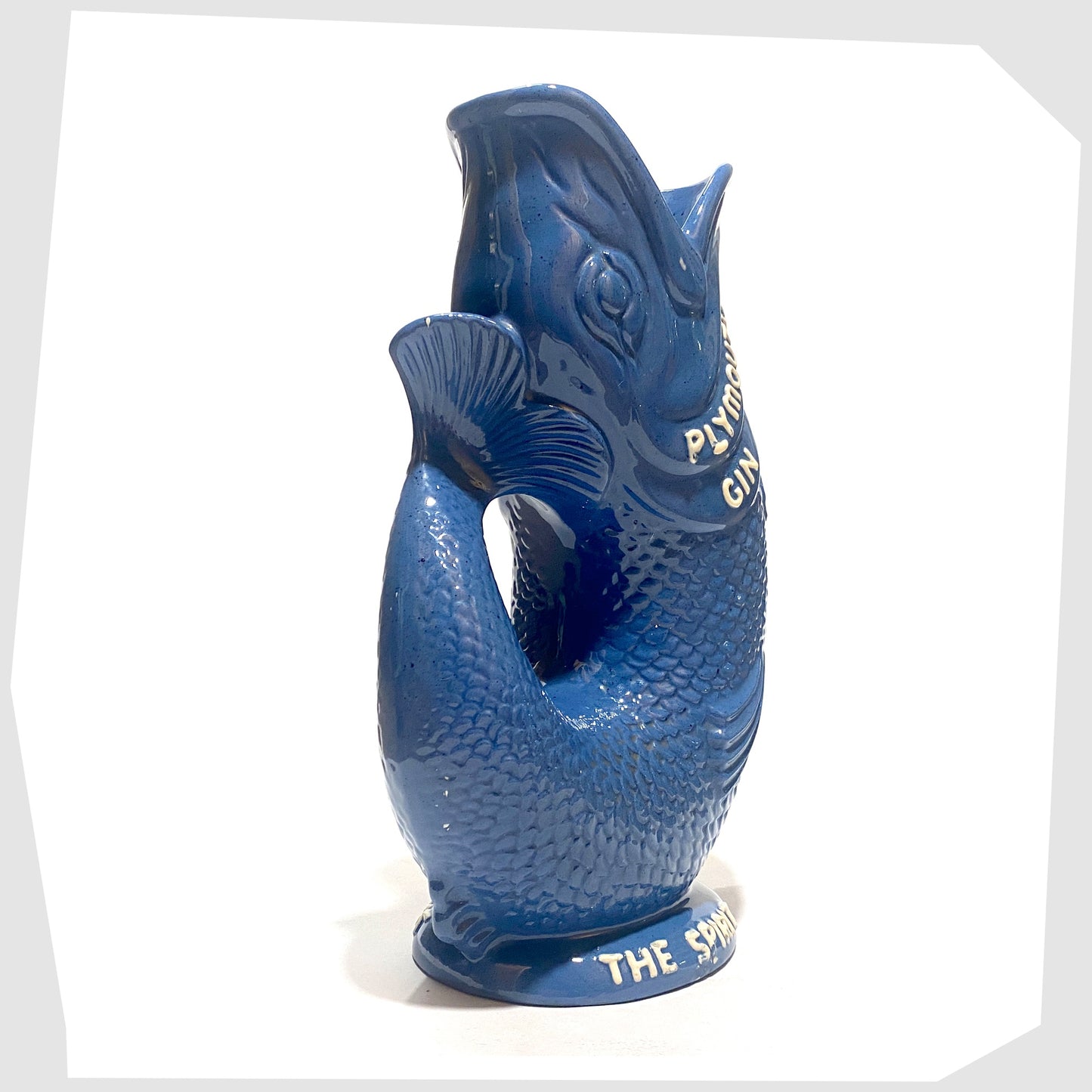 tail/handle of the Dartmouth Pottery Plymouth Gin Gluggle in a sea blue glaze with white text around the spout and base