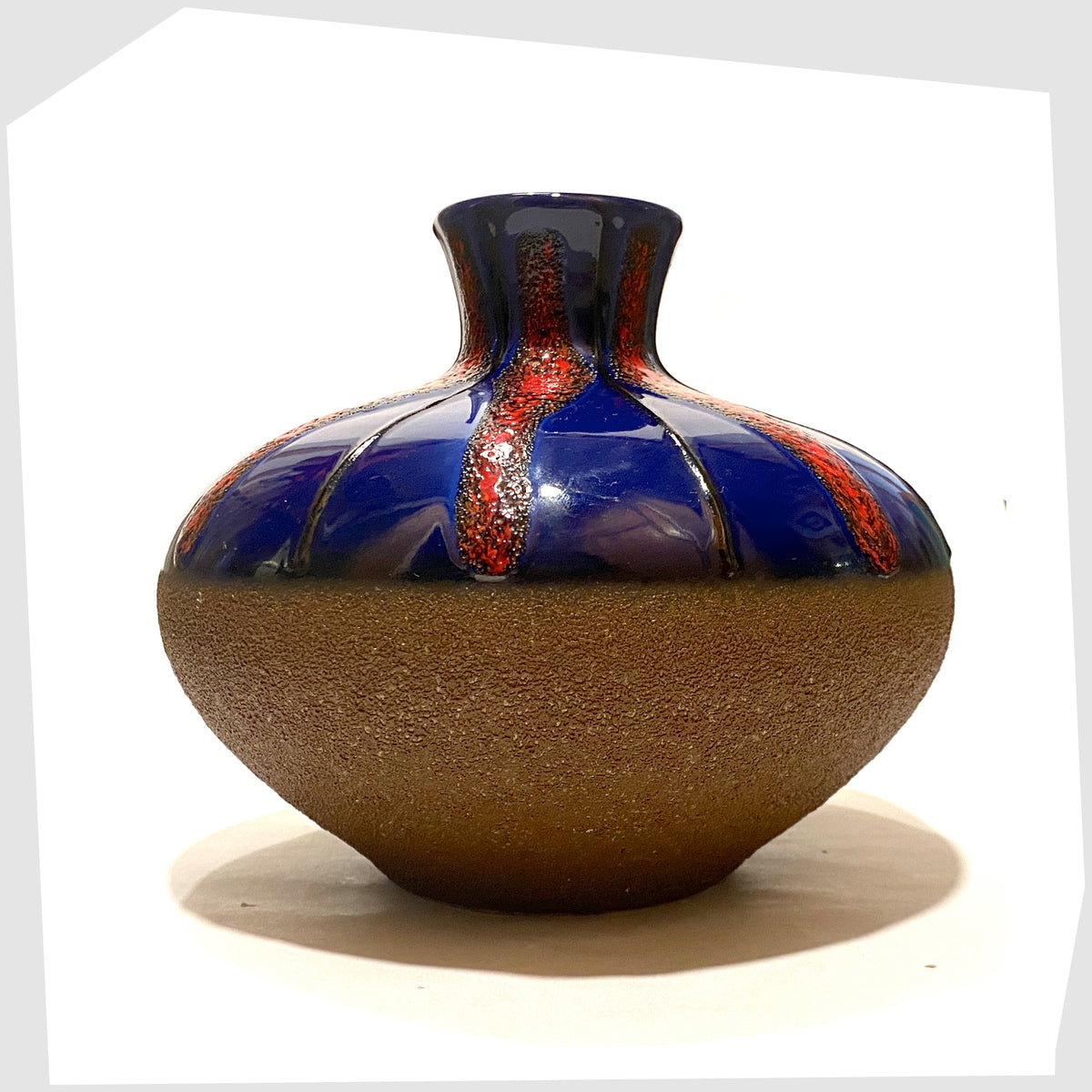 1970s West German Pottery Vase by Dumler and Breiden with a contrasting glaze of matte natural glaze and vivid blue and red fat lava, shown on a white background
