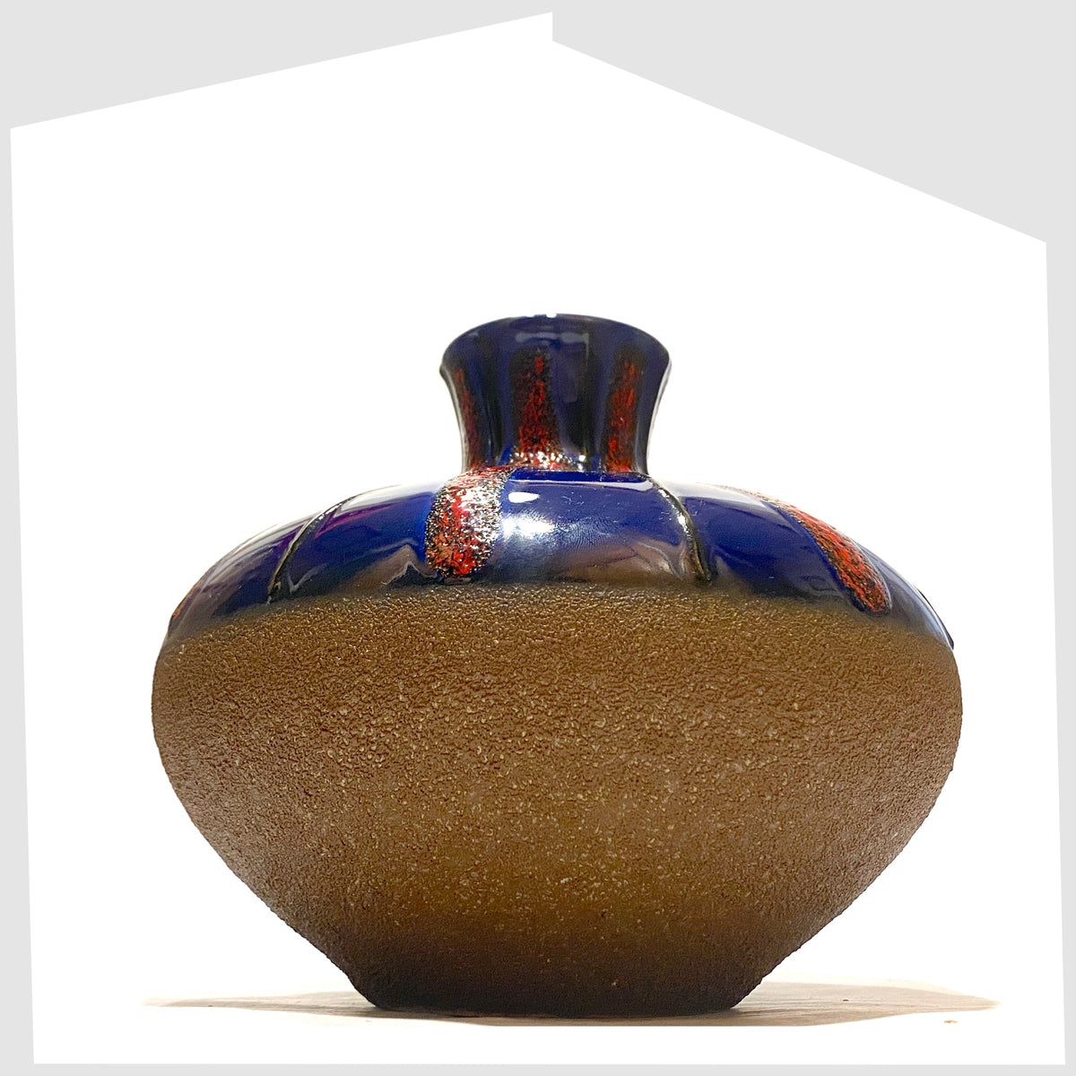 Dumler and Breiden Vase with a contrasting glaze of matte natural glaze and vivid blue and red fat lava, shown on a white background