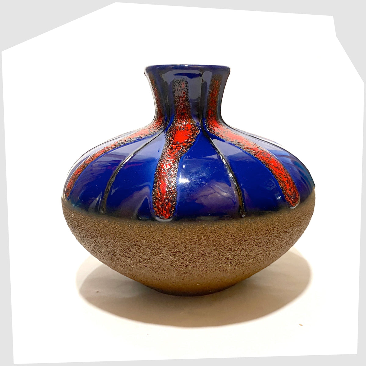 West German Pottery Vase by Dumler and Breiden with a contrasting glaze of matte natural glaze and vivid blue and red fat lava, shown on a white background