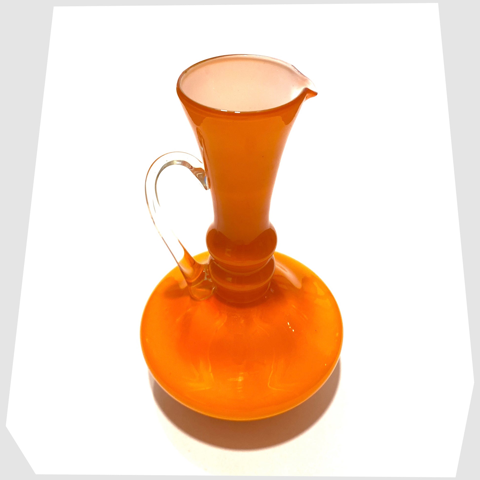 top lip and white inner of the empoli glass jug in vibrant orange cased glass with clear glass handle