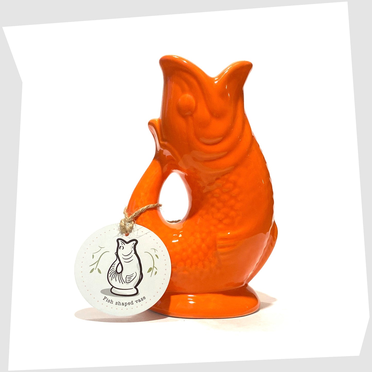 fish-shaped ceramic vase in bold orange glaze shown with its printed card tag