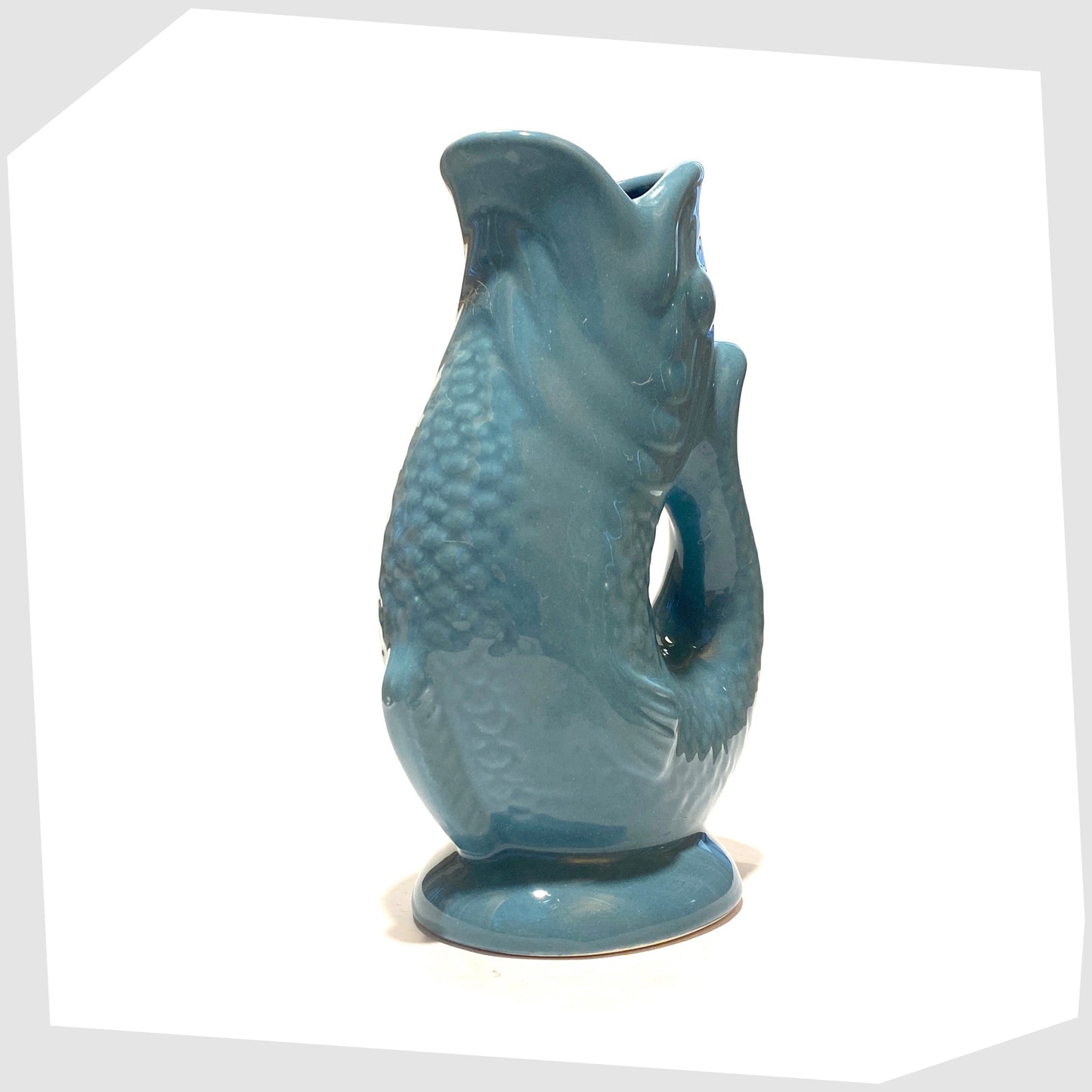 front of the fish-shaped ceramic vase in blue 