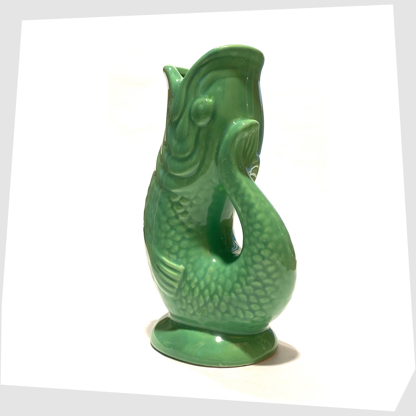 tail of the Ceramic Fish-Shaped Vase in bold green glaze shown with its printed card swing tag