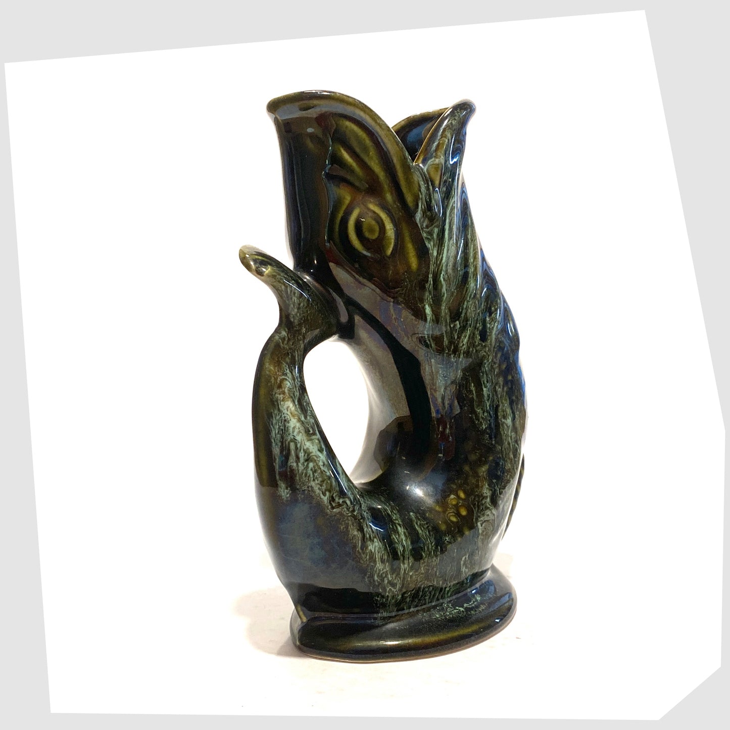tail/handle of the vintage fosters studio pottery gluggle jug in green drip glaze