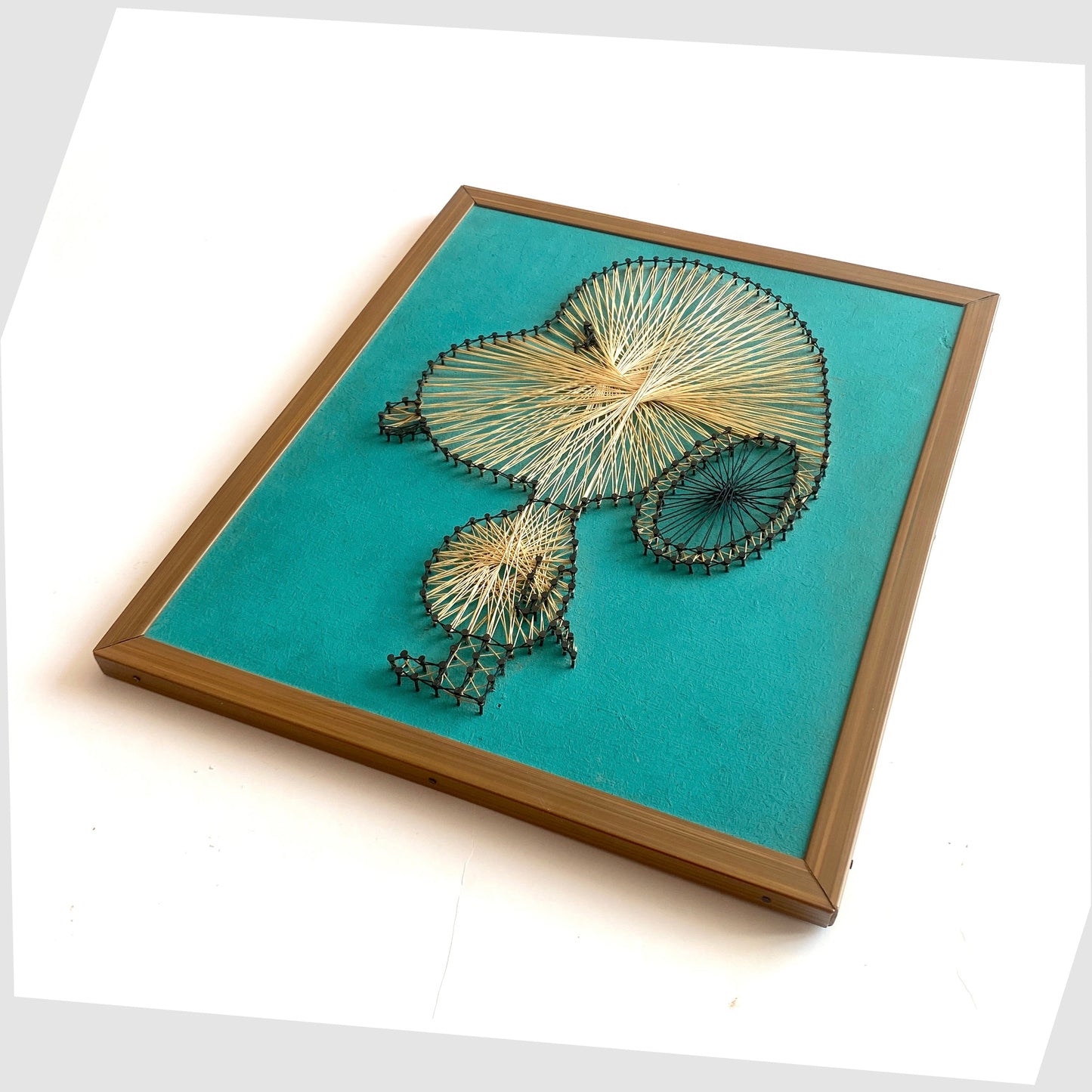 Vintage Framed Snoopy String Artwork, created from beige string and black nails on a teal background, shown on a white background