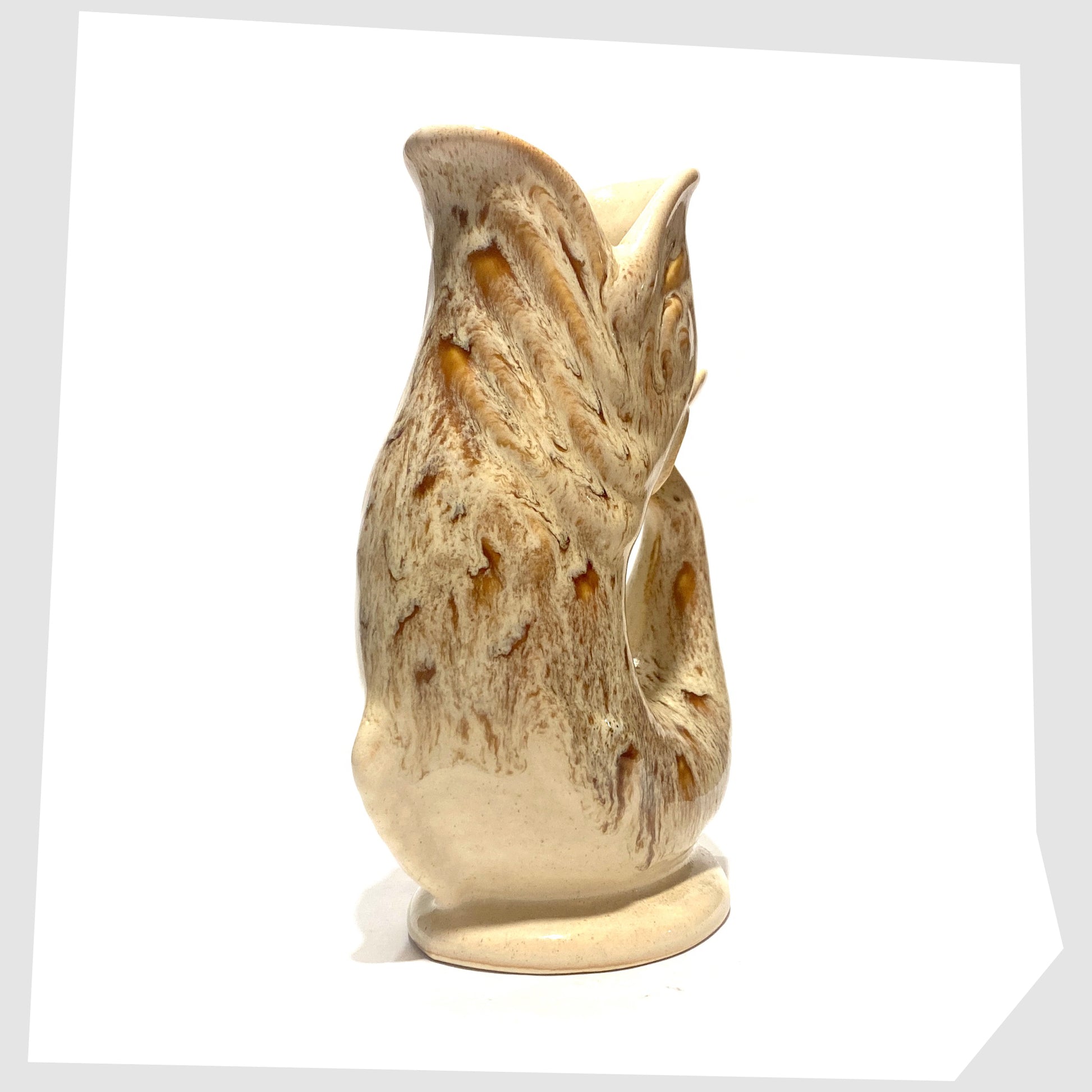 front of the vintage Fosters Studio Pottery Gluggle Jug in a beige and amber honeycomb drip glaze