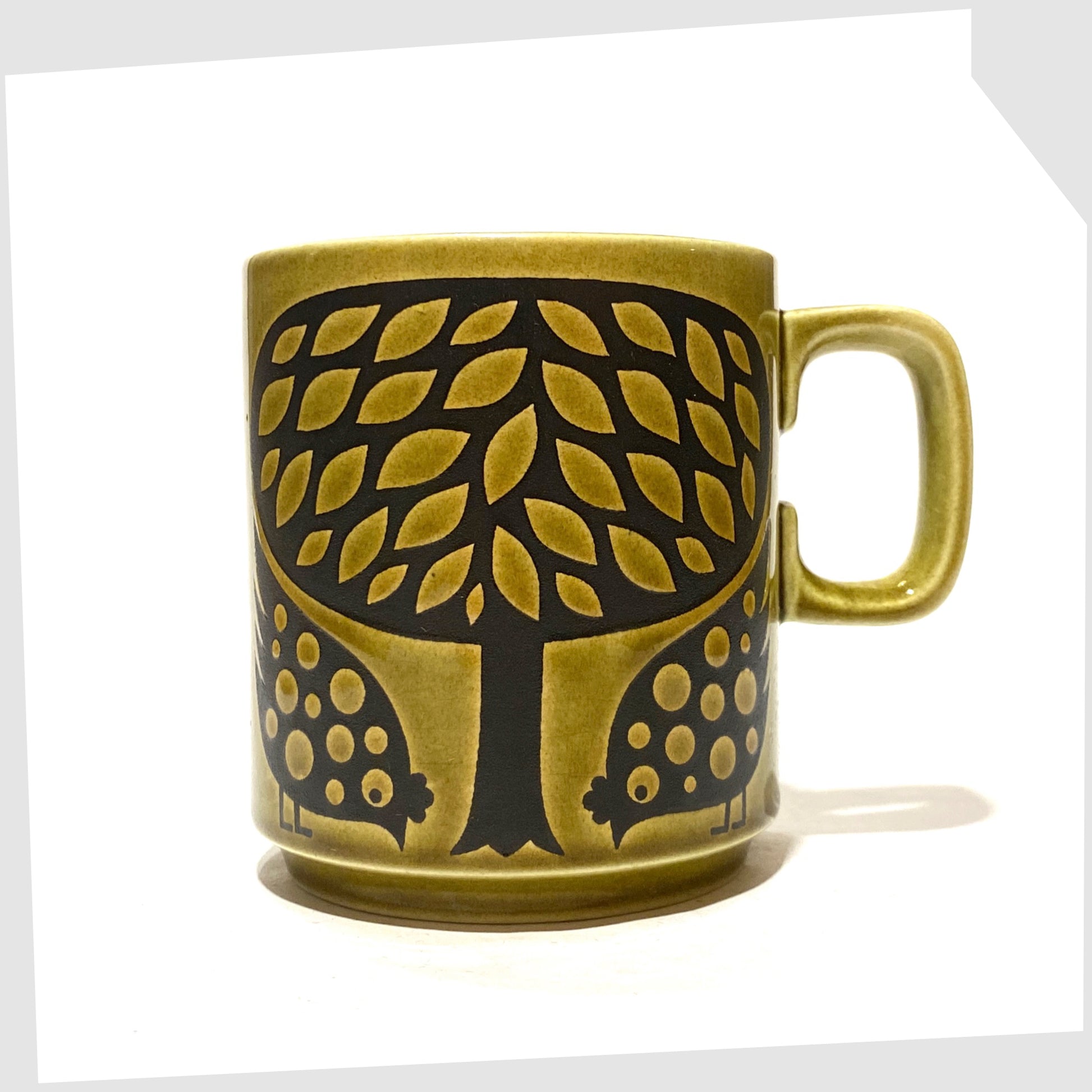 Original Hornsea Pottery Mug featuring a pair of partridge birds at the base of a tree, in an olive green glaze with lack decals, shown on a white background
